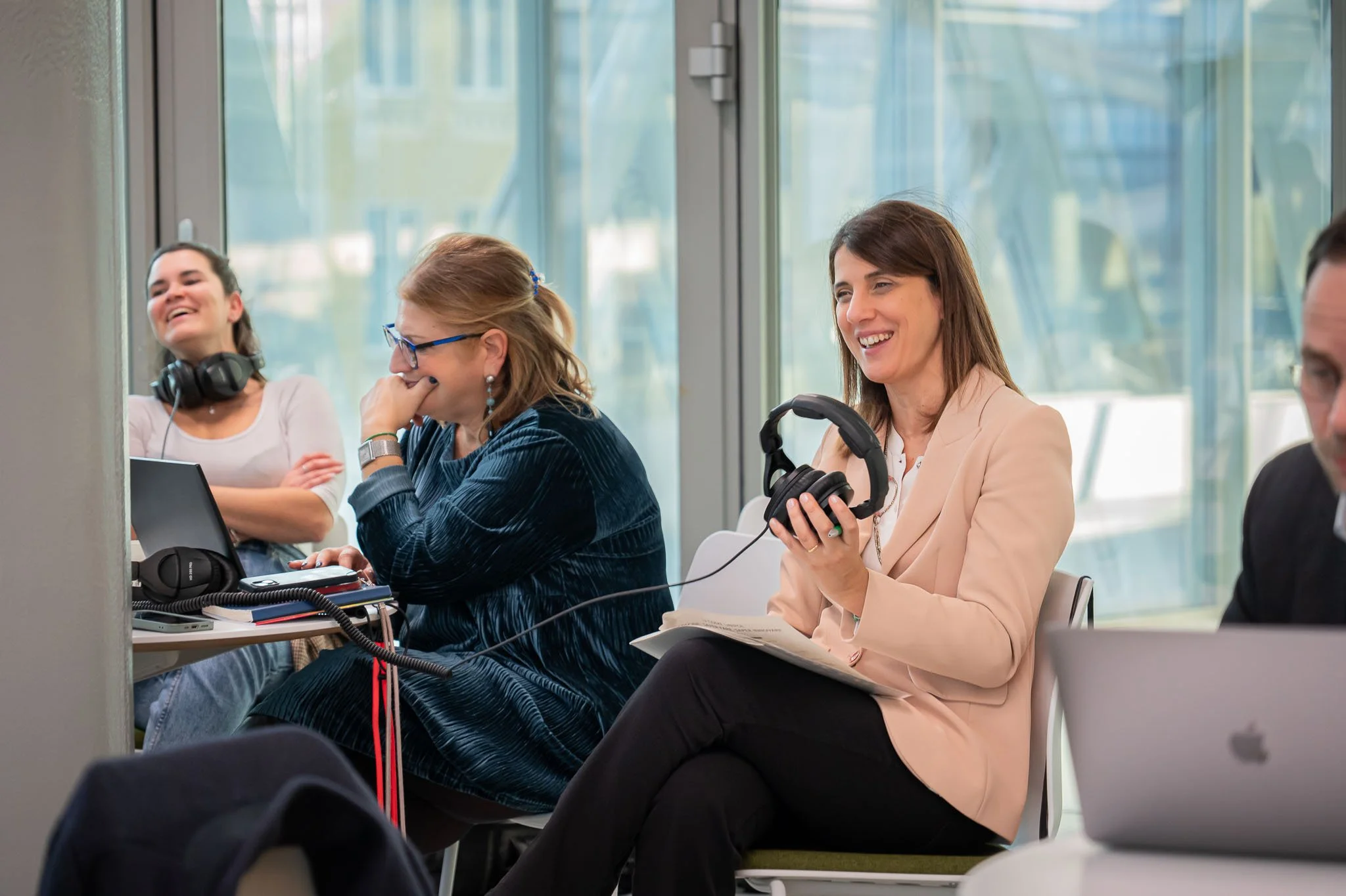 Momento di backstage durante la produzione del podcast Unipol negli uffici aziendali di Milano, con il team al lavoro tra cuffie e appunti.
