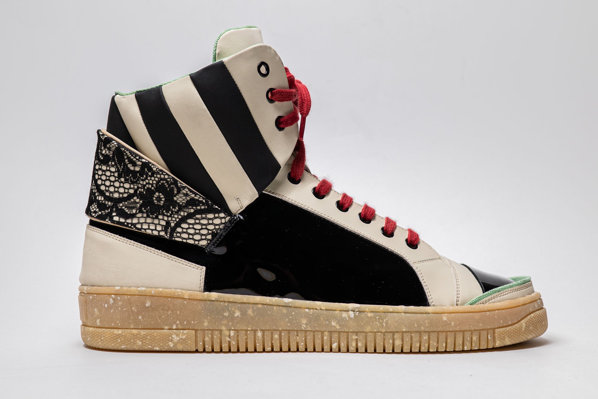 Prototipo di sneaker artigianale con dettagli grafici in bianco rosso e nero realizzato dagli studenti dell’Arsutoria School