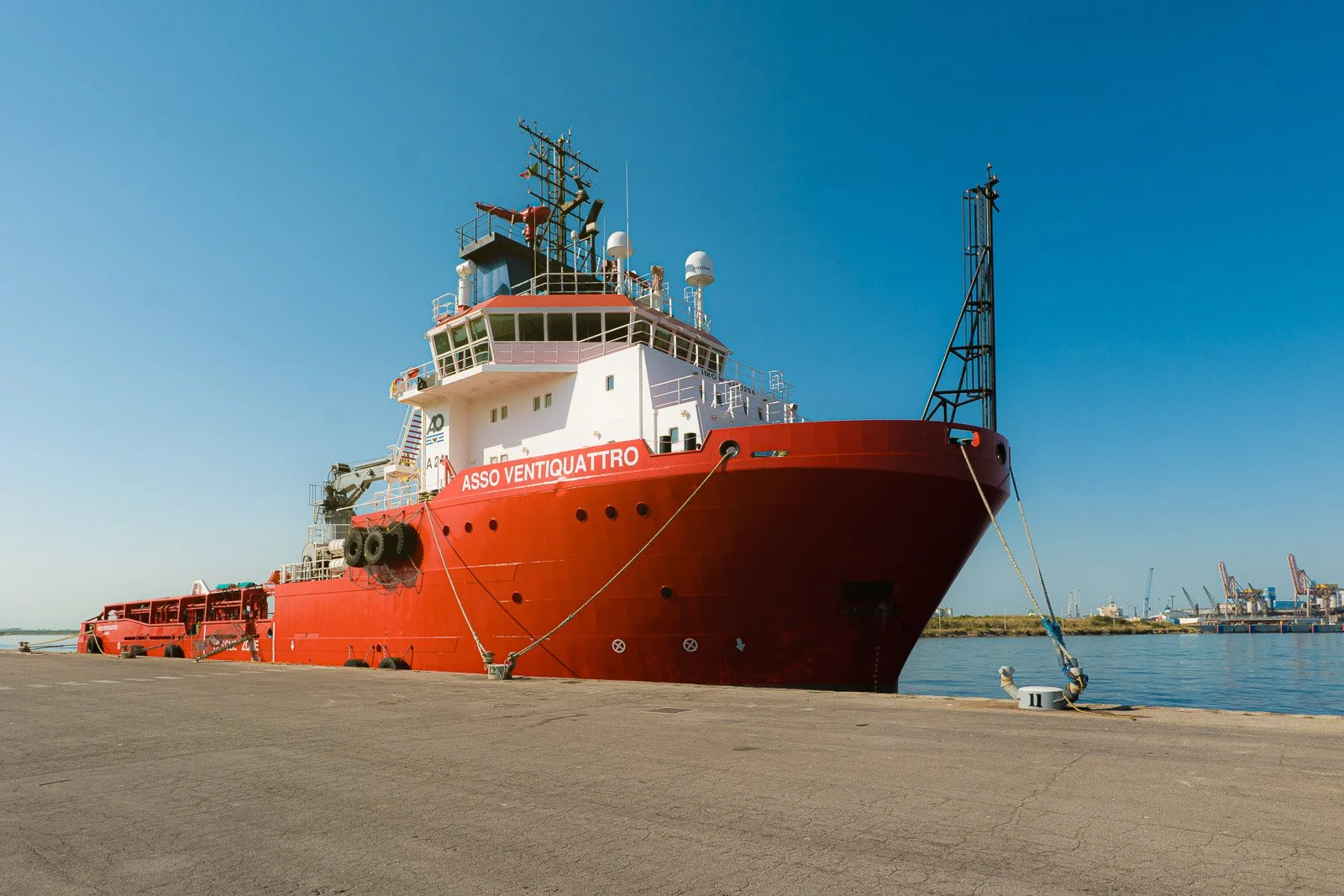 La nave Asso Ventiquattro, con scafo rosso e sovrastruttura bianca, ormeggiata alla banchina del porto.