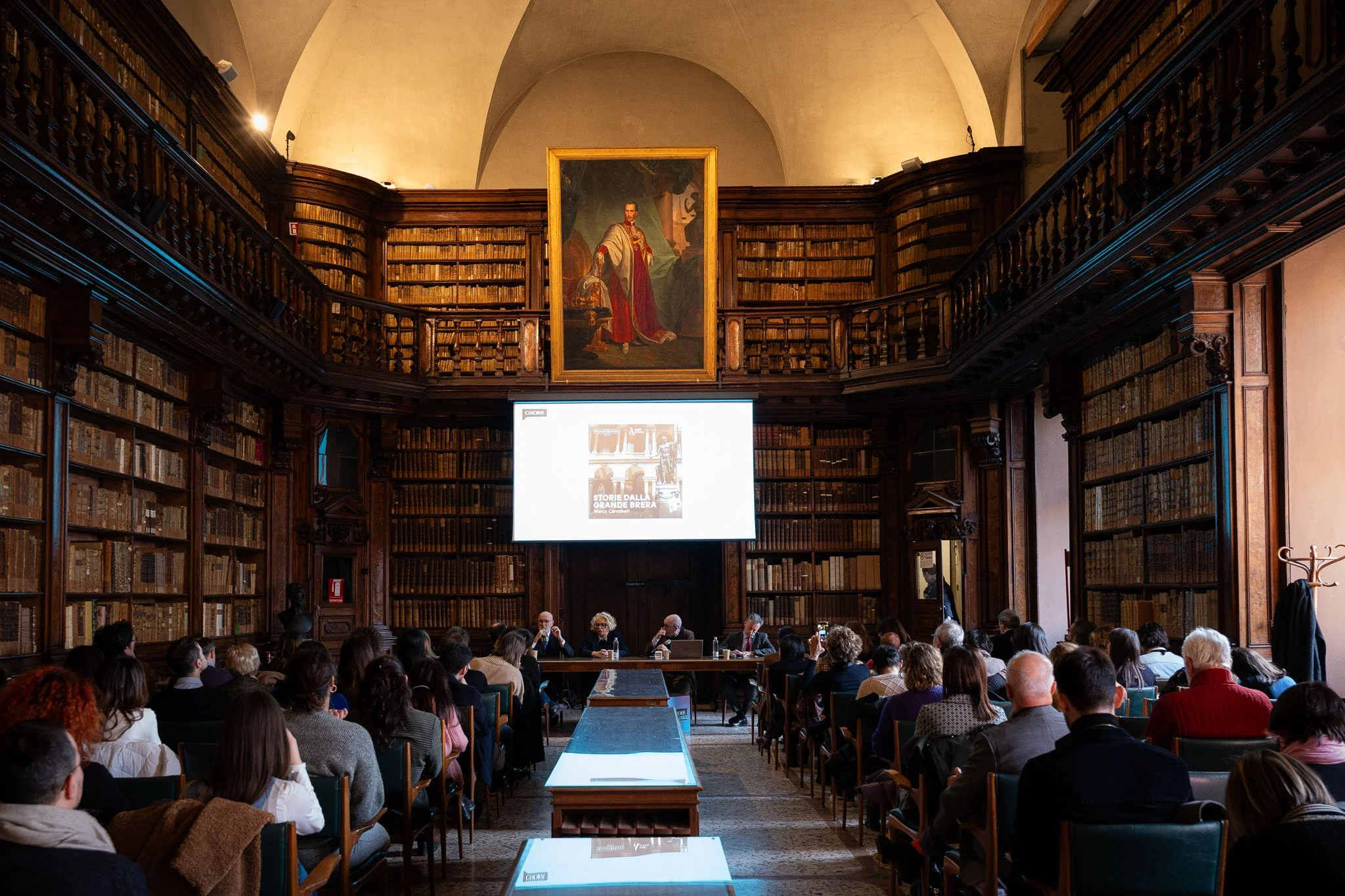 Evento Chora V2 nella Biblioteca Braidense di Milano con pubblico e tavolo relatori ripreso frontalmente