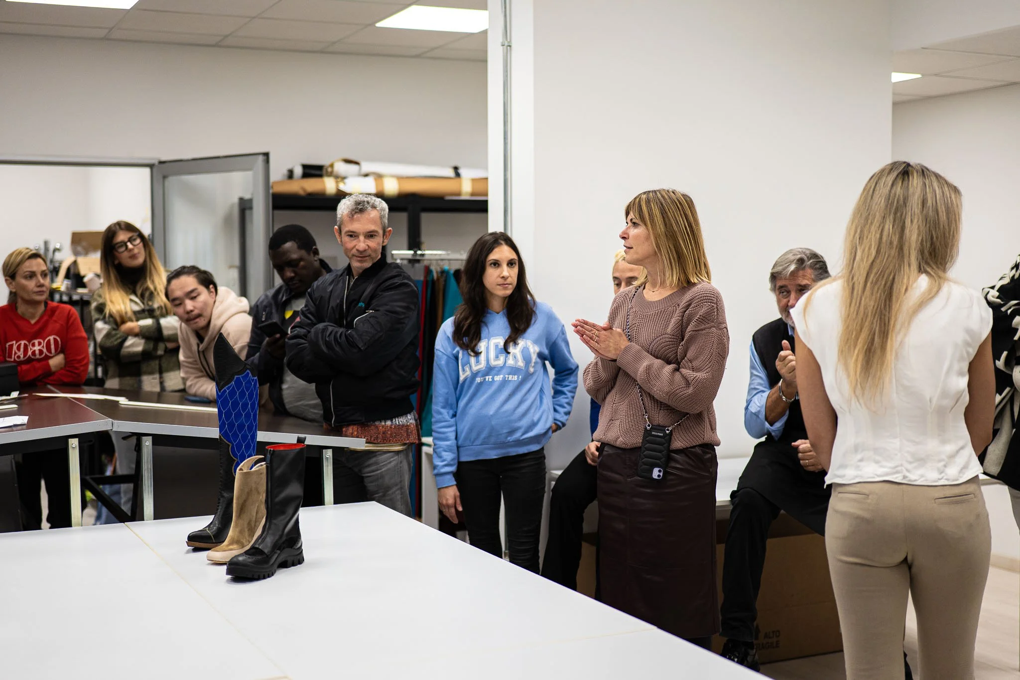 Il gruppo di studenti osserva i prototipi di calzature durante la sessione di fitting all'Arsutoria School a Milano