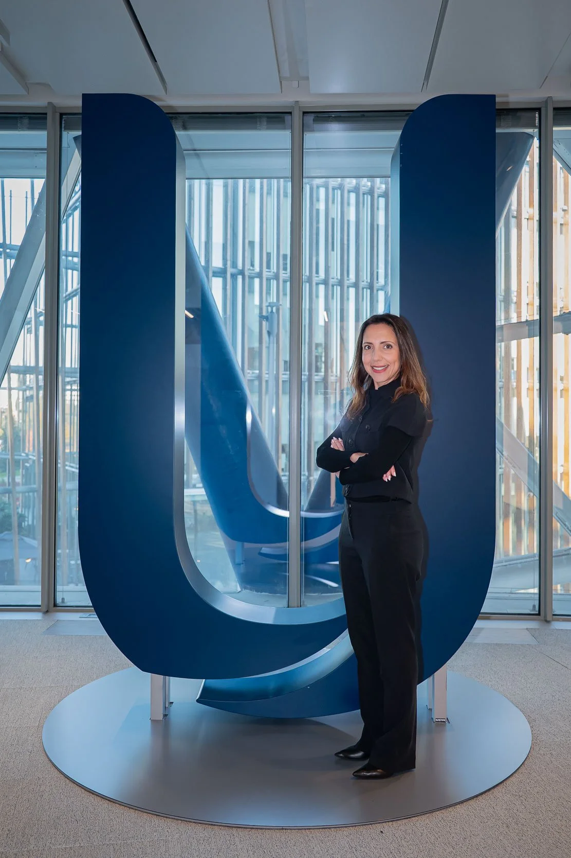 Ritratto dell’ospite davanti al logo Unipol negli uffici aziendali di Milano, realizzato prima della registrazione del podcast.
