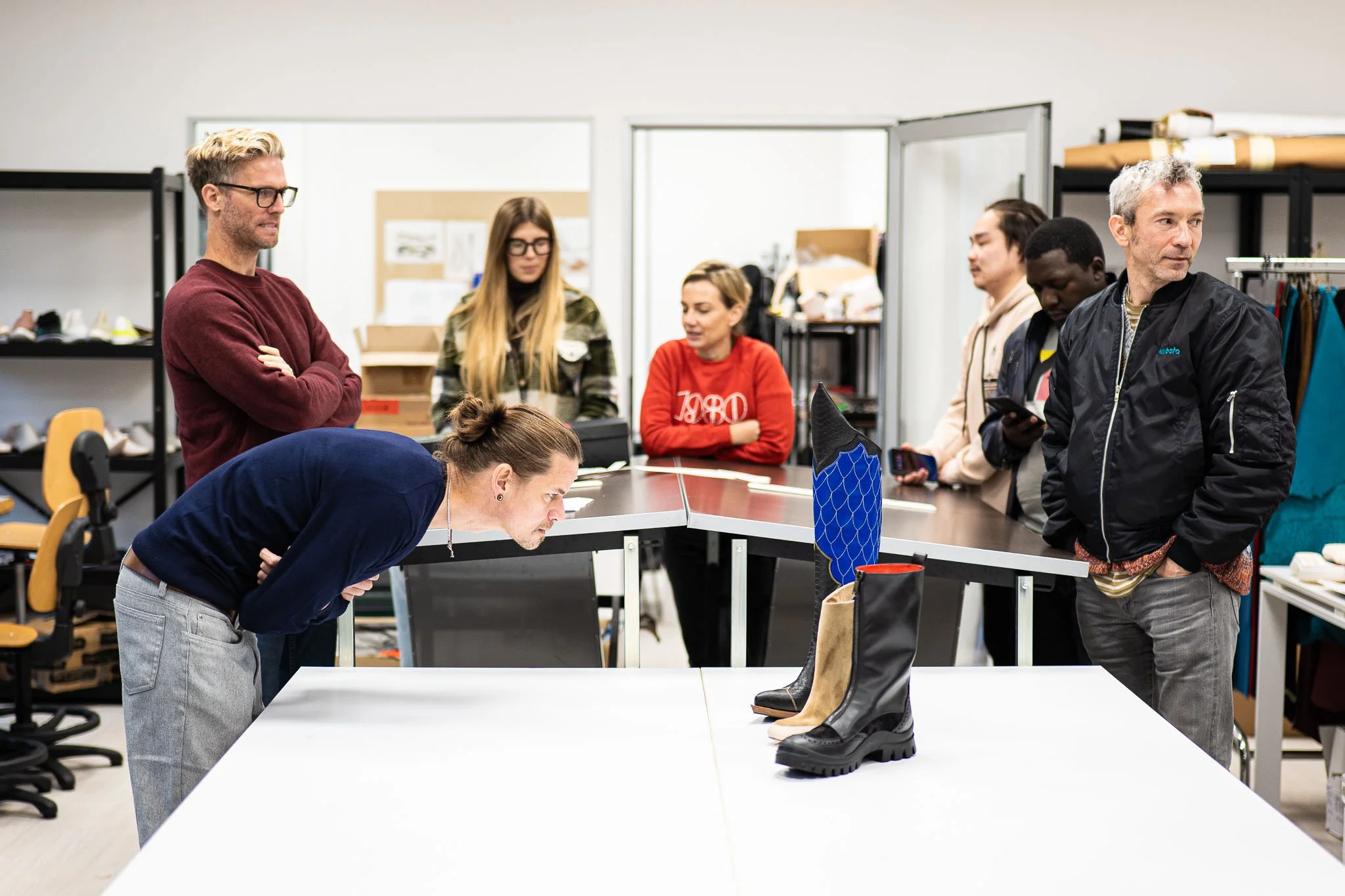Gli studenti osservano da vicino i prototipi di calzature durante la sessione di fitting all'Arsutoria School a Milano