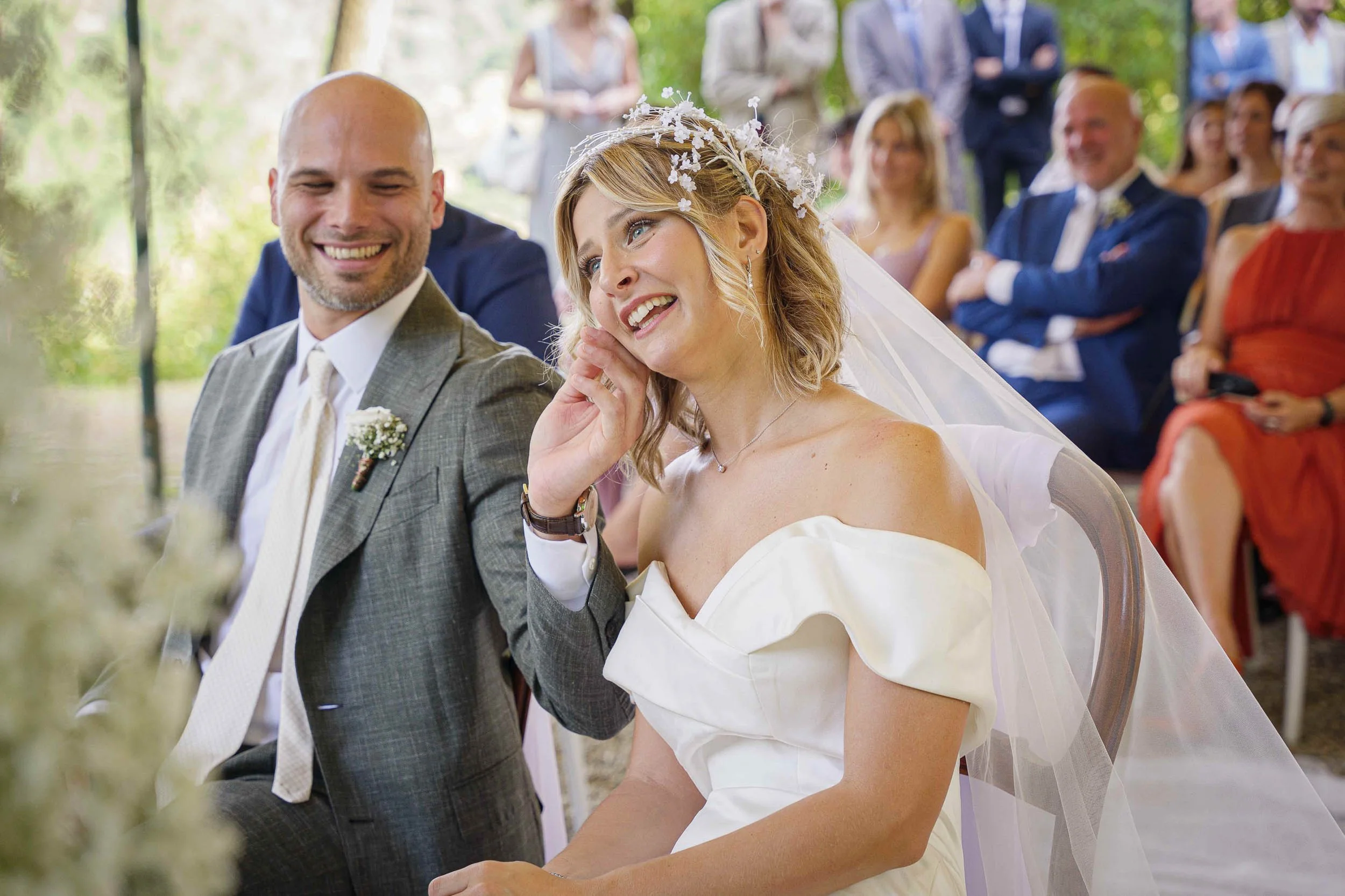 Sposa che sorride tra le lacrime durante la cerimonia nuziale all’aperto a Tenuta Montezeglio Invorio, momento intimo carico di emozione