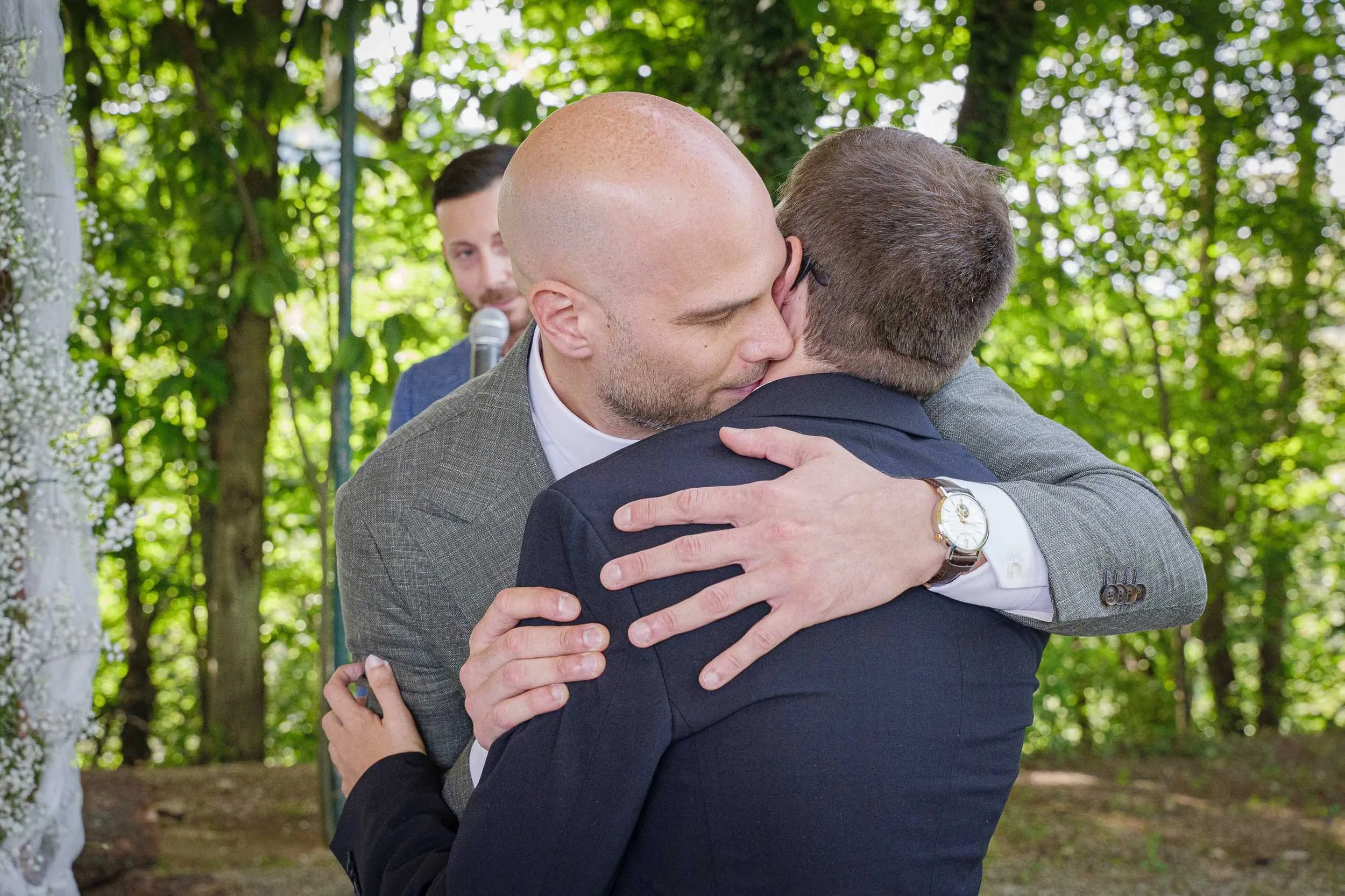 Sposo che abbraccia suo fratello vicino all’altare durante il matrimonio a Tenuta Montezeglio Invorio, momento spontaneo e affettuoso