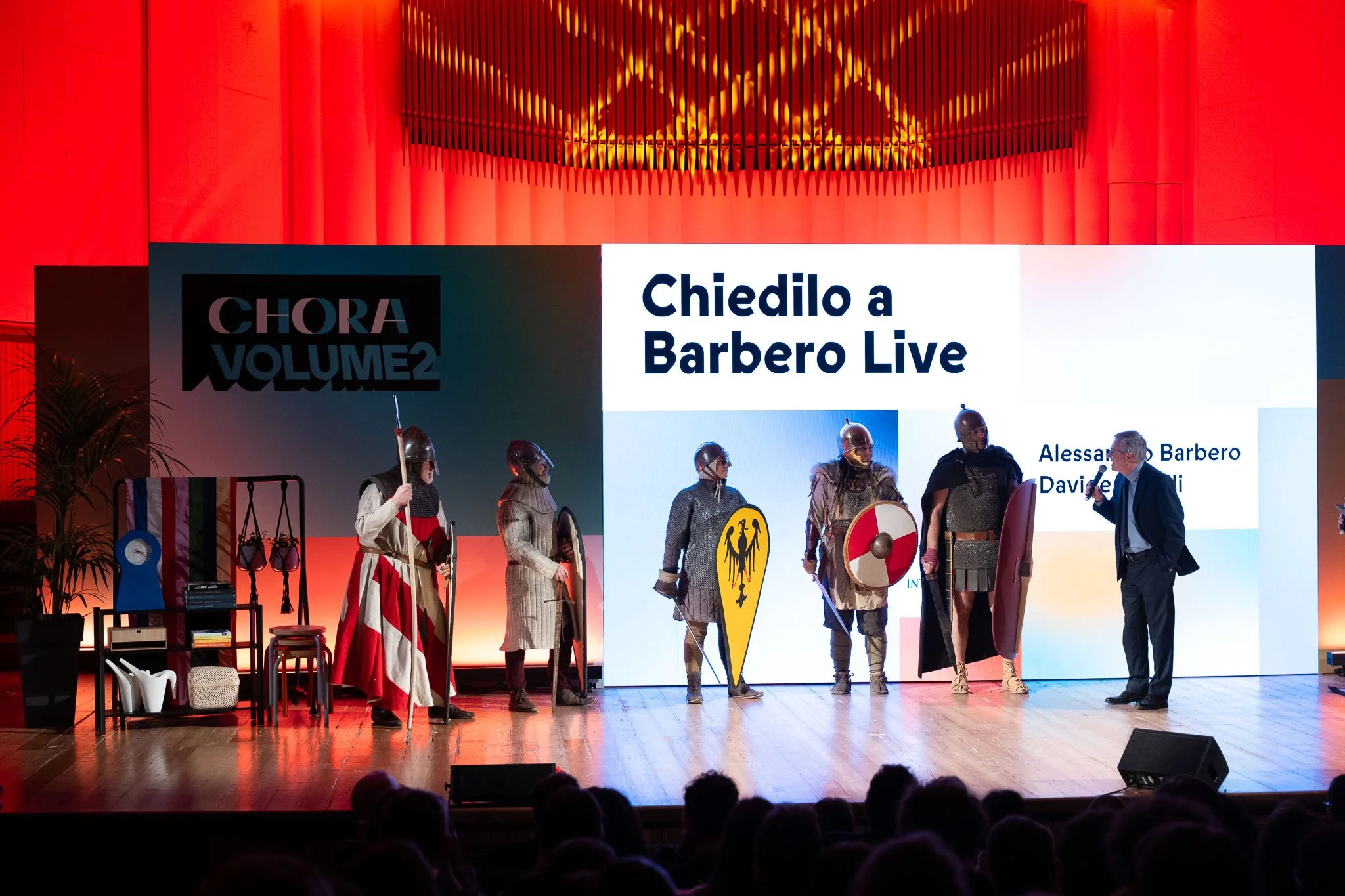 Alessandro Barbero insieme ai rievocatori storici sul palco durante lo spettacolo Chiedilo a Barbero Live all’evento Chora V2 al Conservatorio G Verdi di Milano