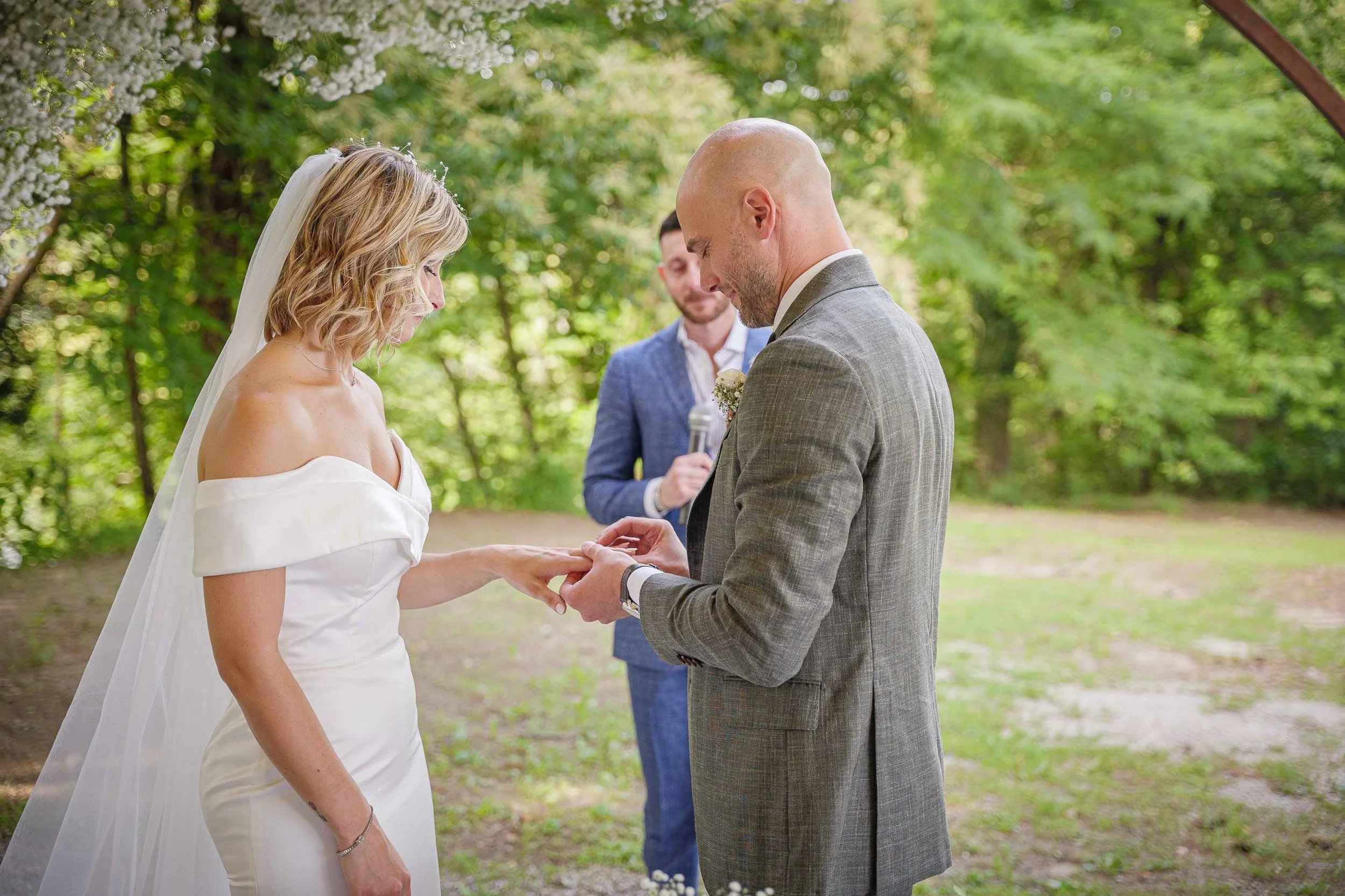 Scambio degli anelli durante la cerimonia nuziale all’aperto a Tenuta Montezeglio Invorio, momento simbolico immortalato in modo elegante