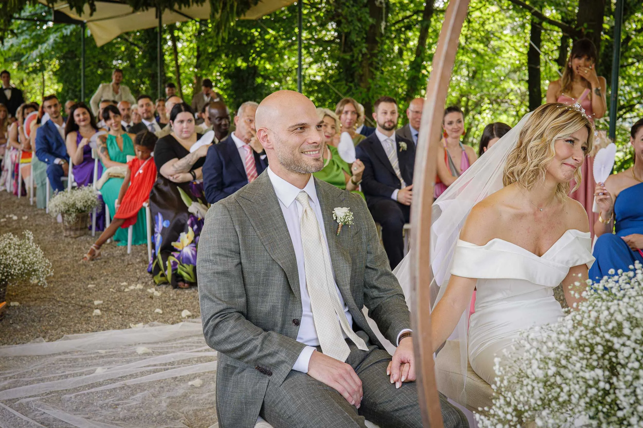 Sposi che si tengono per mano durante la cerimonia all’aperto a Tenuta Montezeglio – matrimonio Paolo e Camilla a Invorio