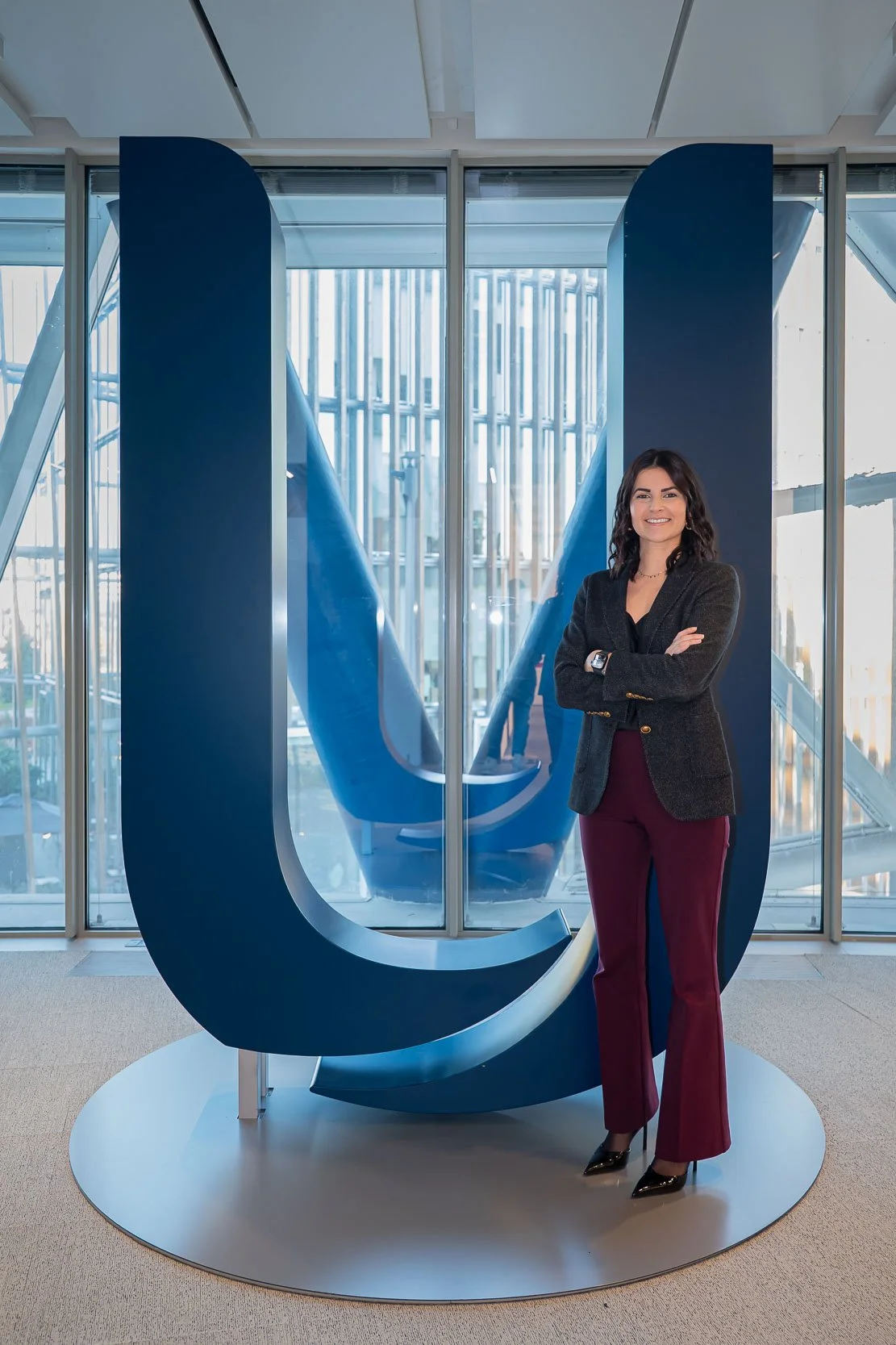 Ritratto dell’ospite davanti al logo Unipol negli uffici aziendali di Milano, realizzato prima della registrazione del podcast.
