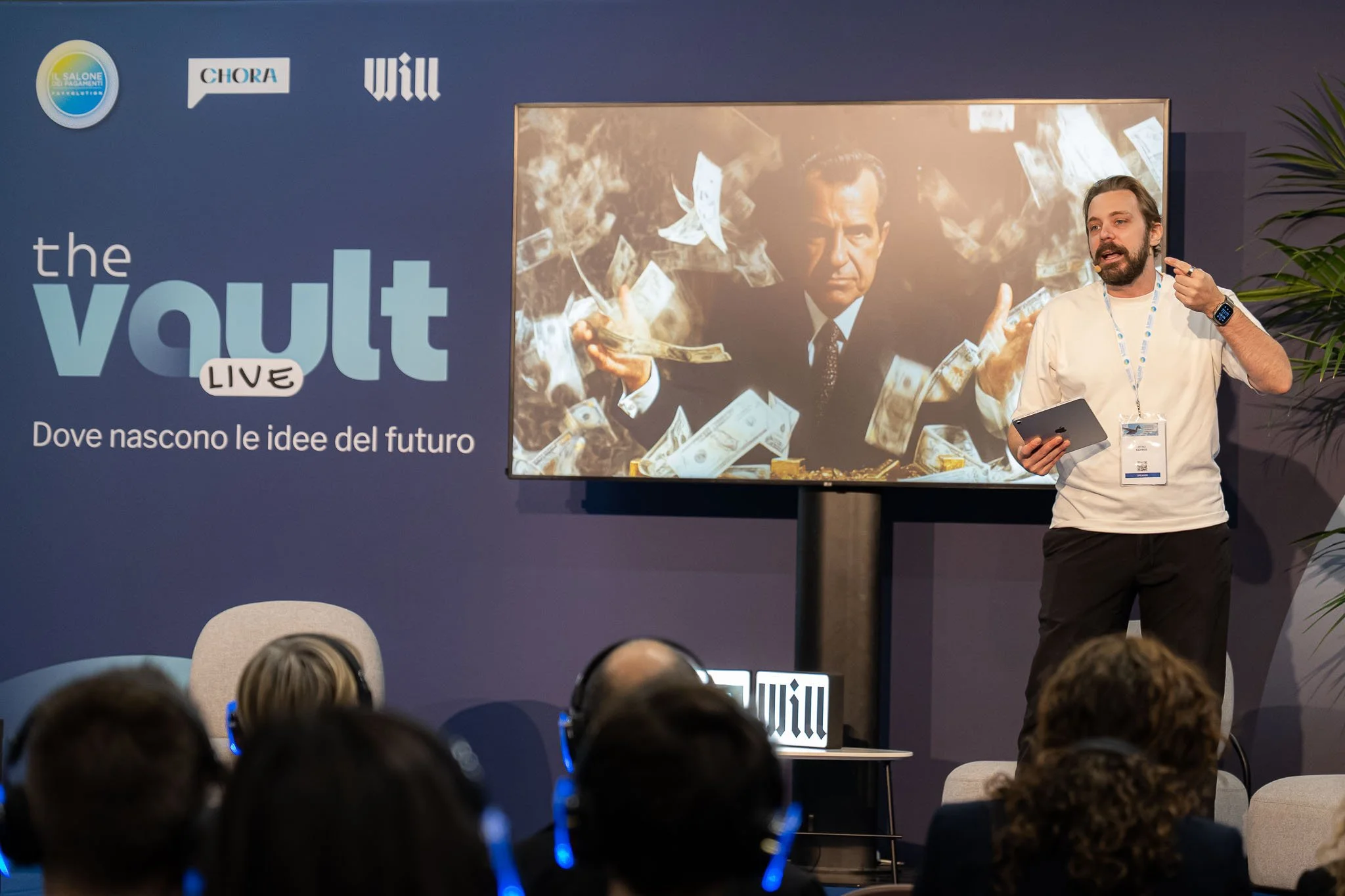 Intervento sul palco durante The Vault Live al MiCo di Milano, con presentazione visiva e pubblico in ascolto. Reportage fotografico dell’evento per Will Media e Chora Media.
