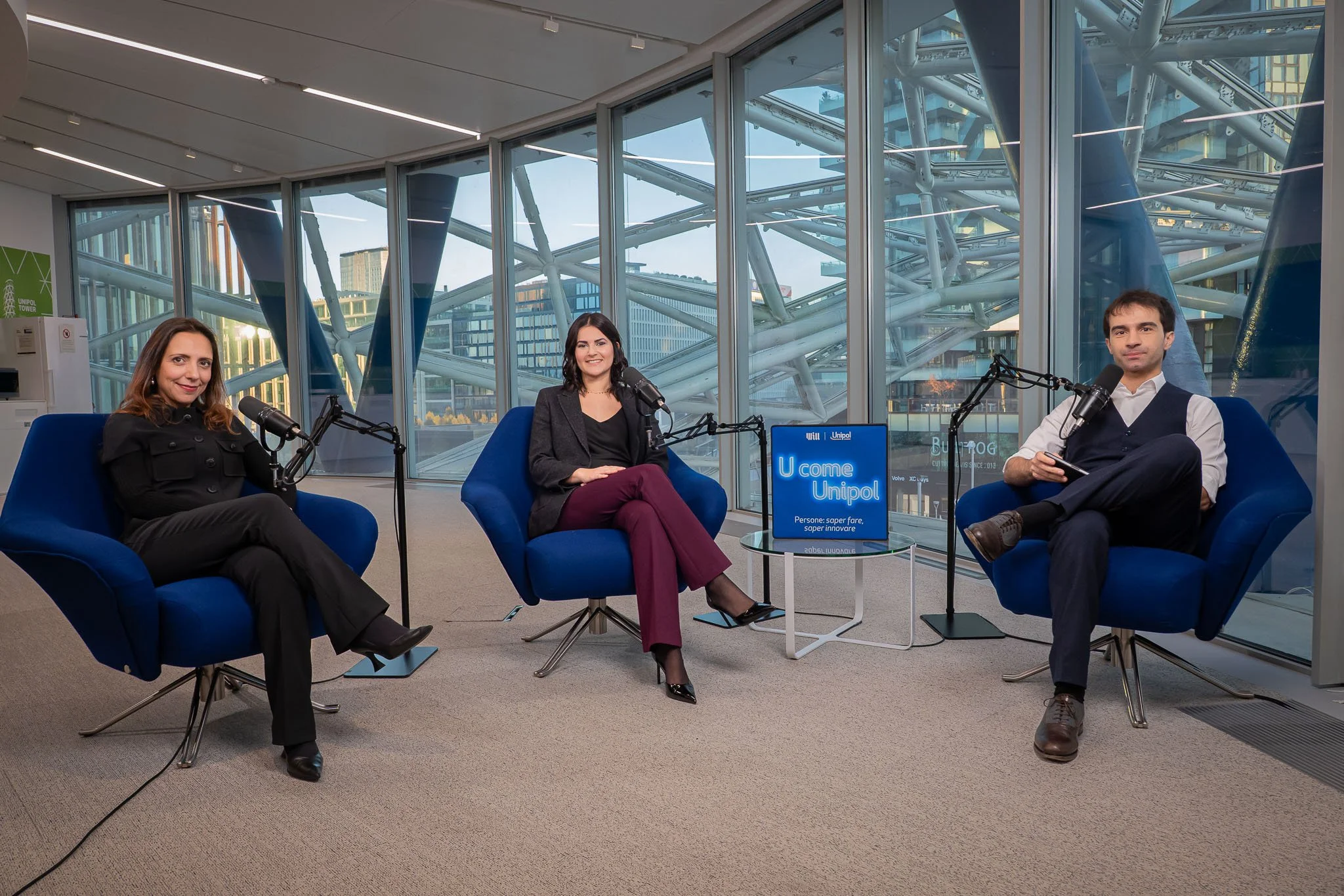 Intervista a tre ospiti durante la registrazione del podcast Unipol negli uffici aziendali di Milano, con set completo e vista sull’architettura del palazzo.
