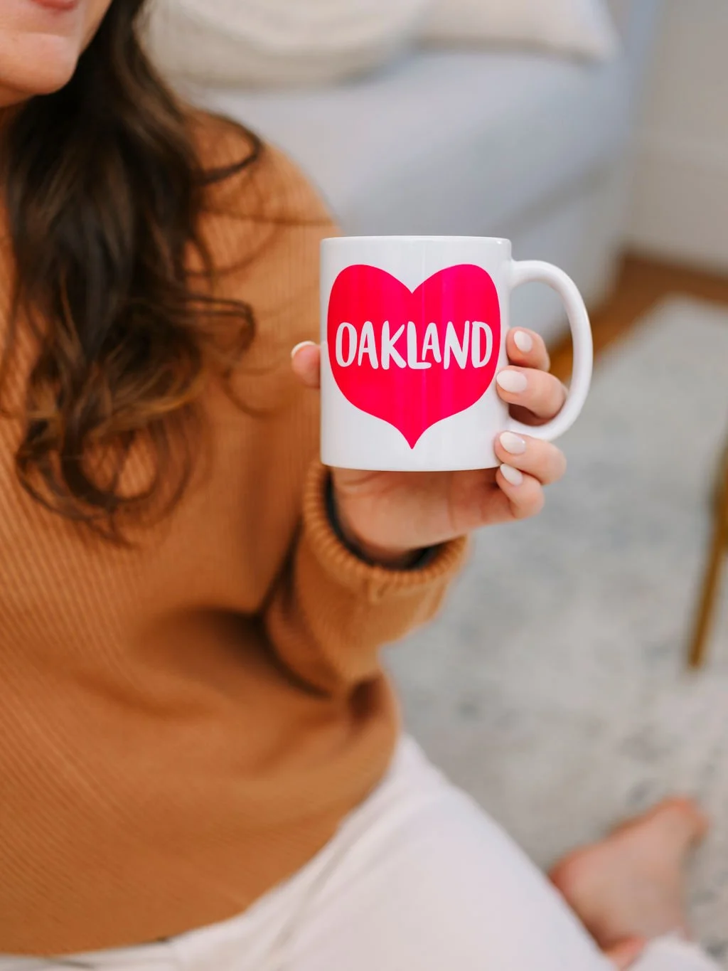 Mary Fleisch LCSW holding an "Oakland" coffee cup