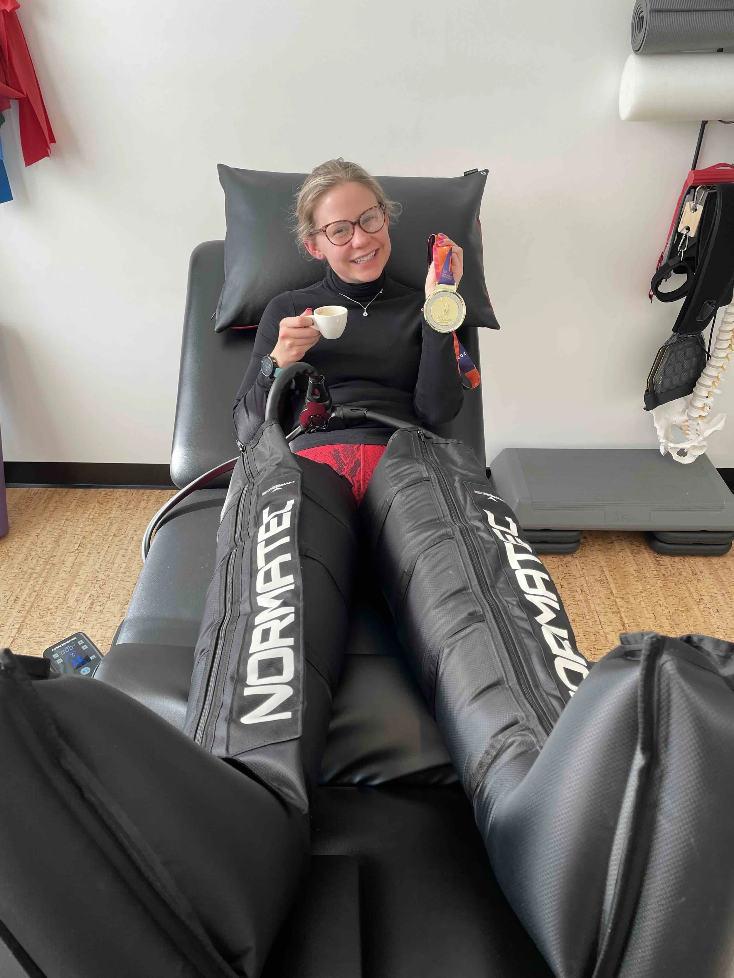 A client using NormaTec boots to recover who successfully completed a marathon.