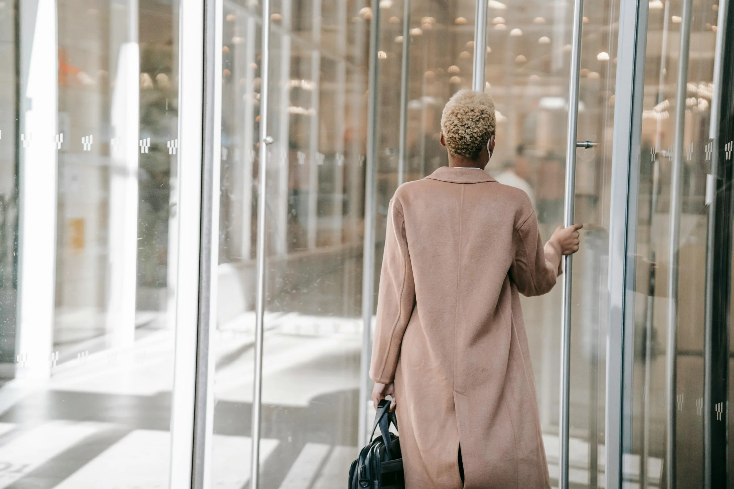 Woman leaving an glass office through the door