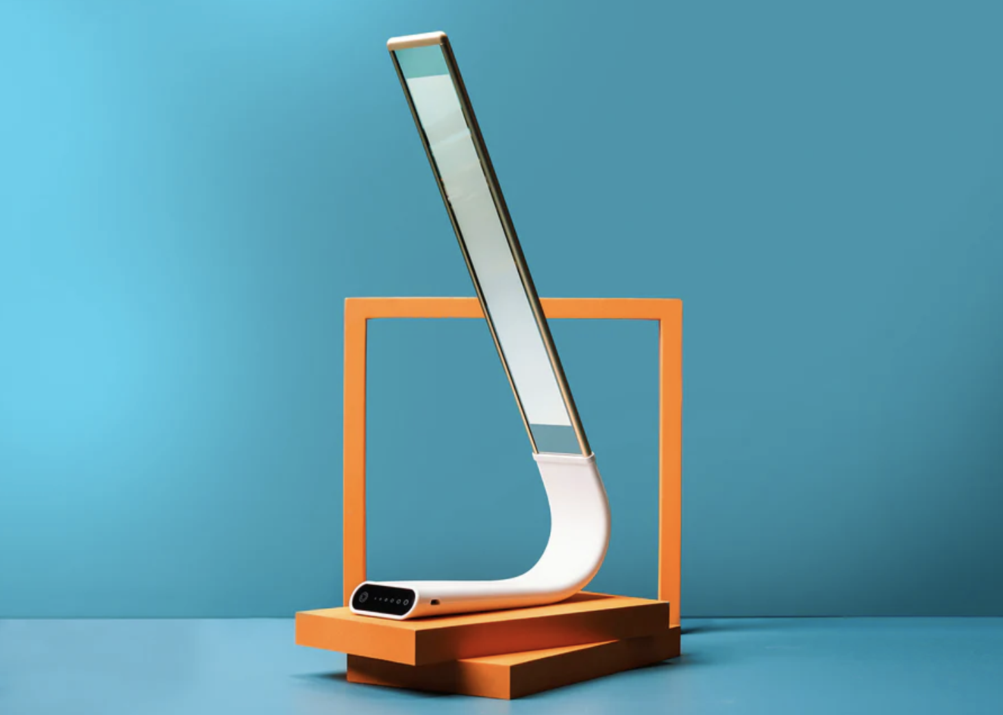 Modern abstract sculpture with a curved design and rectangular frames against a blue background.
