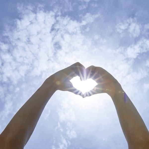 Distance Ensofic Reiki Hands forming a heart around sunlight representing Distance Ensofic Reiki healing