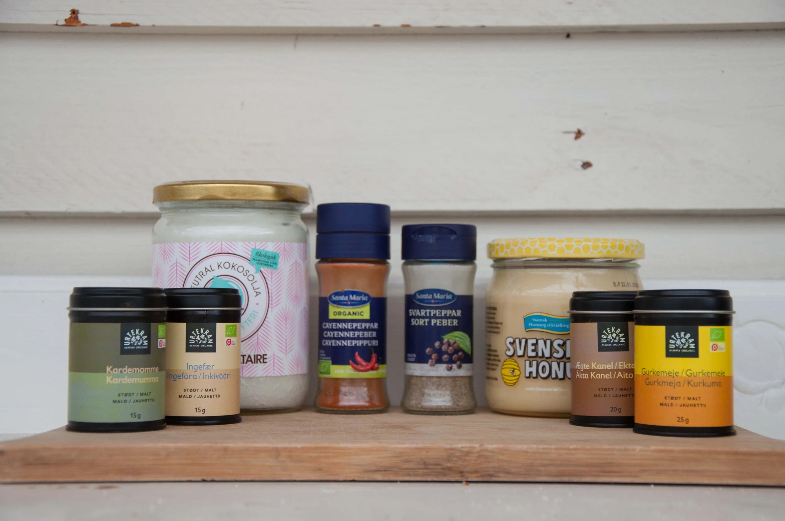 Burkar med kokosolja, honung och kryddor som är ingredienser i guldmjölk