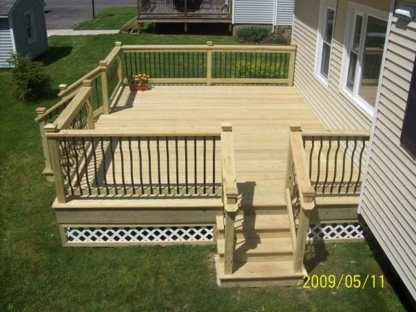 This cozy deck was built with two stairway access points to create a more open feel to the space. Beautiful carpentry work, featuring a classic deck skirt, fence, and railing. 