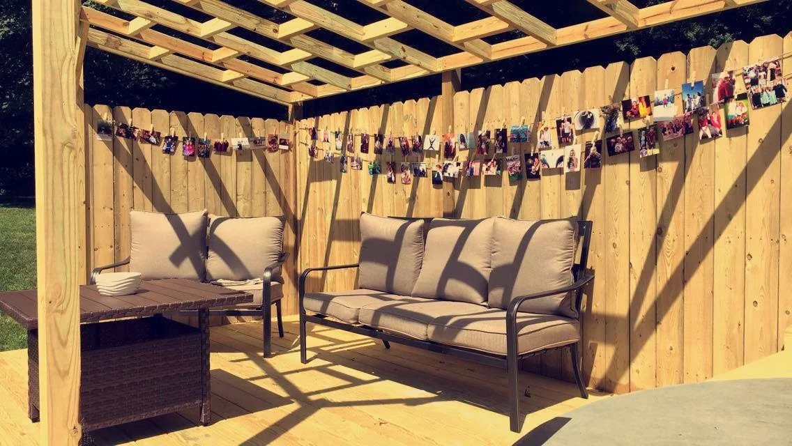 This custom deck was constructed around a hot tub, featuring a storage cabinet for hot tub supplies and a shade pergola. 