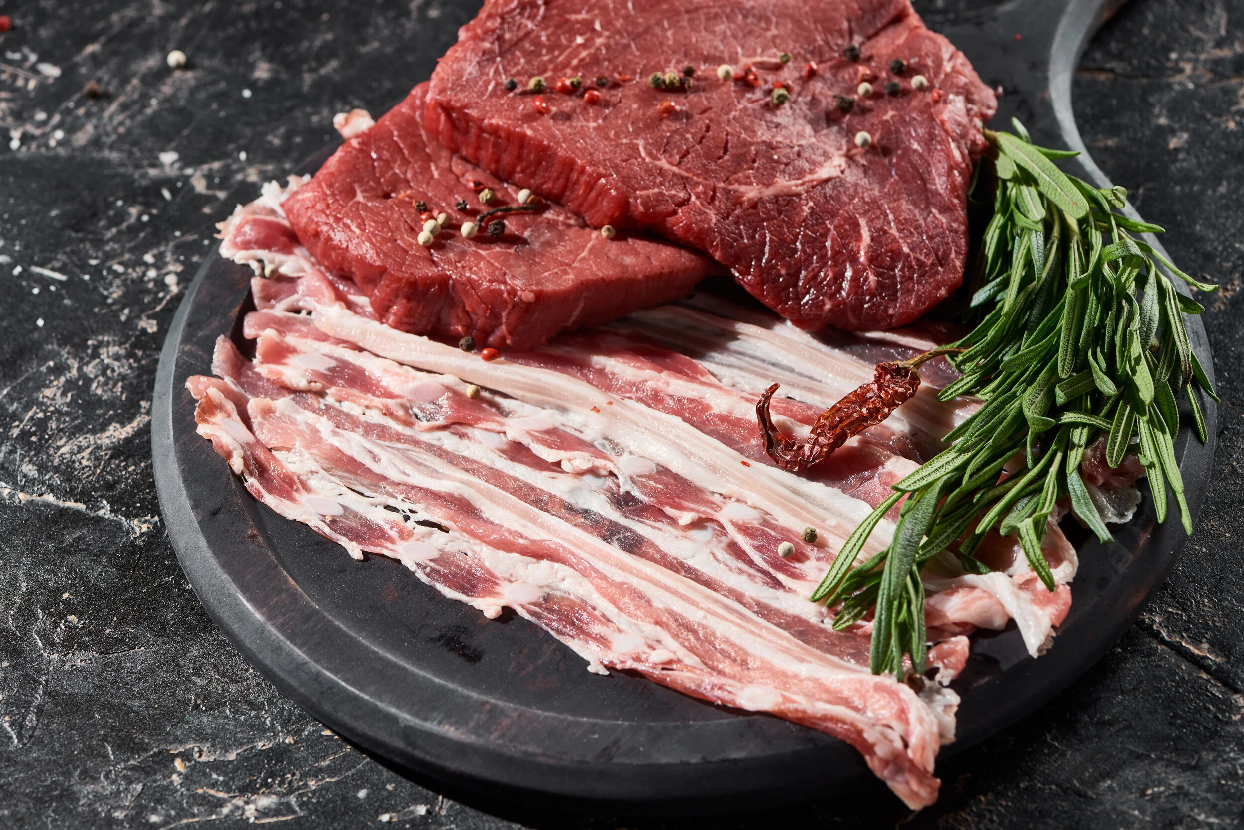 wooden-pan-with-raw-beef-steaks-and-bacon-slices-n-9KCYDUL.jpg