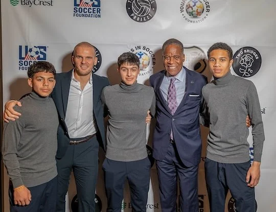 🌟 Inspiring & Mission-Driven (Best for the main gallery)
"A night to celebrate the future of the game. Our Two Bridges boys alongside Ed Foster-Simeon, President & CEO of the U.S. Soccer Foundation, at our annual gala. Together, we’re leveling the p