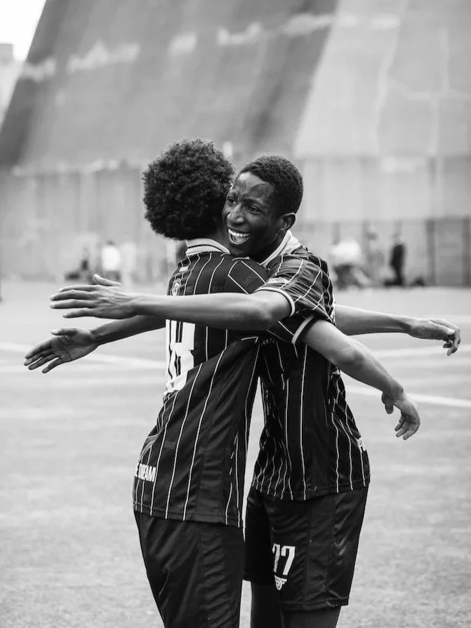 Two Bridges players share a huge celebratory hug after securing an incredible win against an MLS Academy.