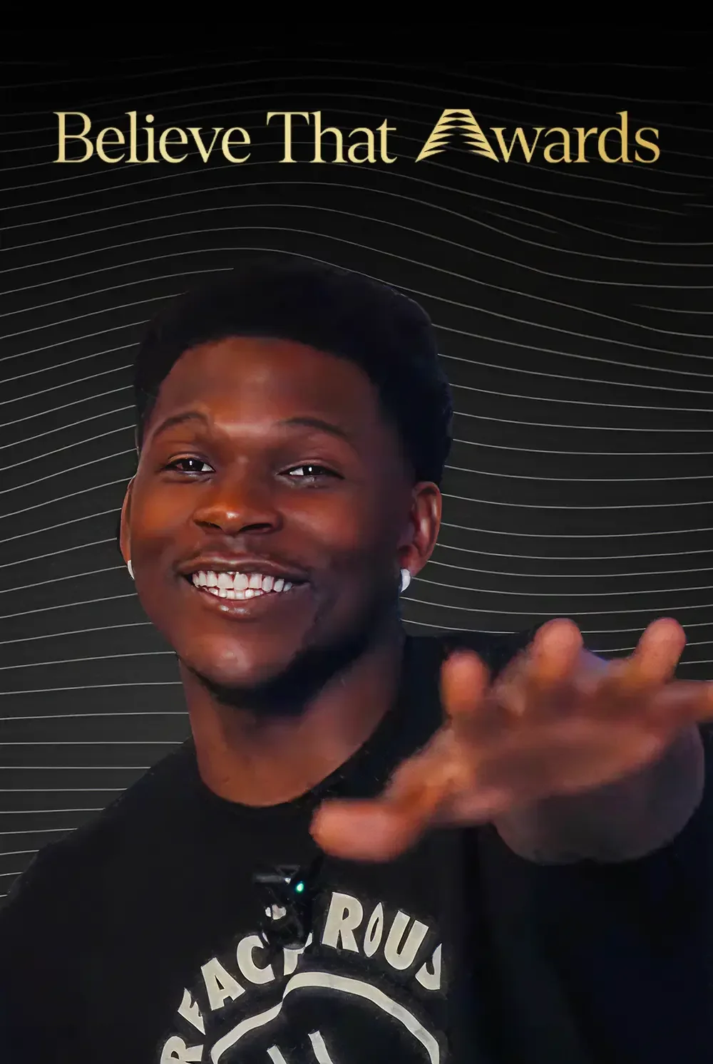 A person smiling and reaching towards the camera in front of a black background with the text 'Believe That Awards' at the top.