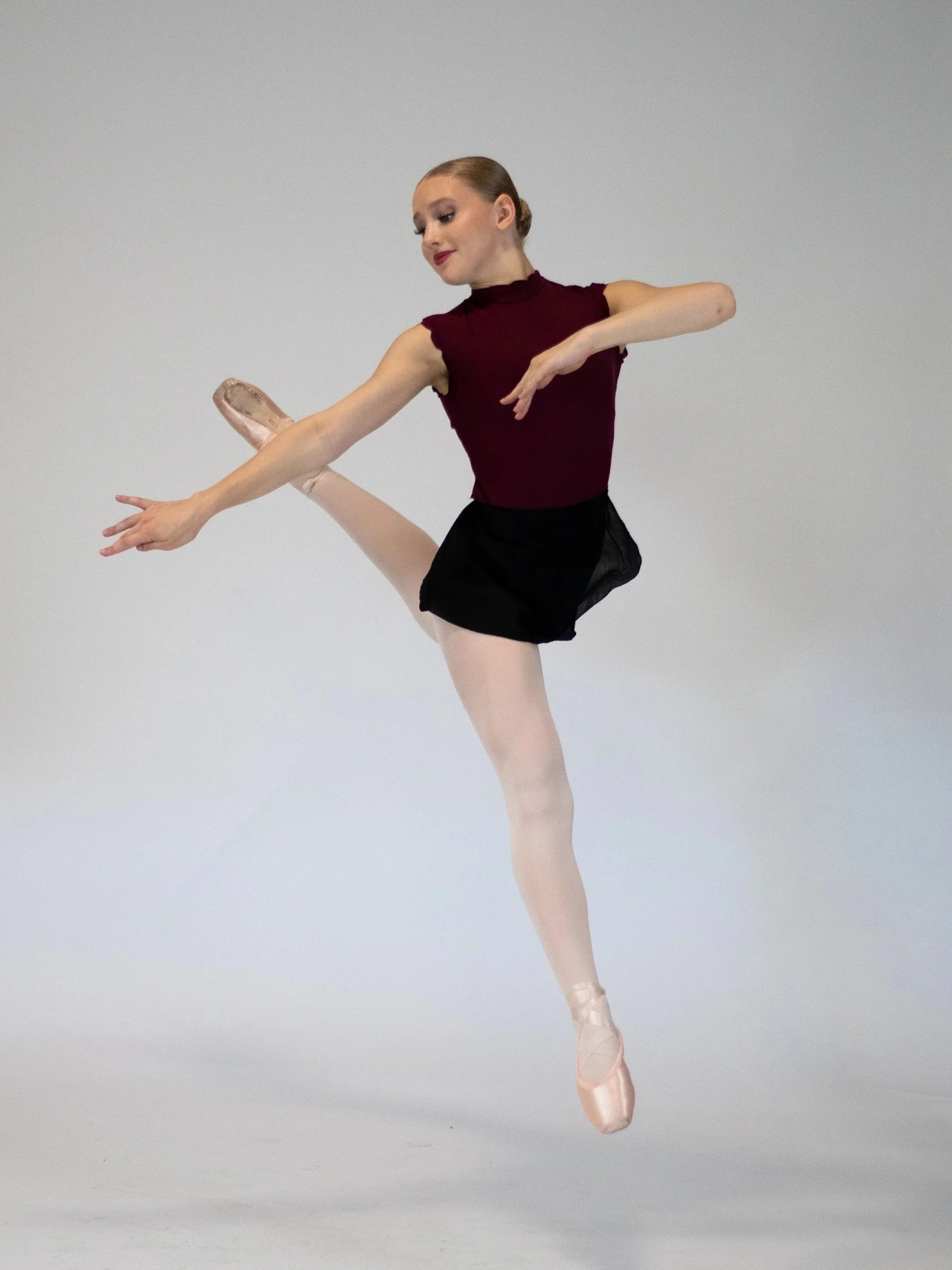 Ballet dancer performing an arabesque in a studio