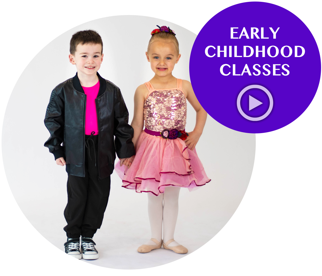 Two young children, a boy and a girl, holding hands and smiling at the camera. The girl is wearing a pink dress with a sequined top and floral belt, and the boy is wearing a black jacket and pants with sneakers. The background is white. A purple circle on the top right has text that reads "Early Childhood Classes" and a play button icon.