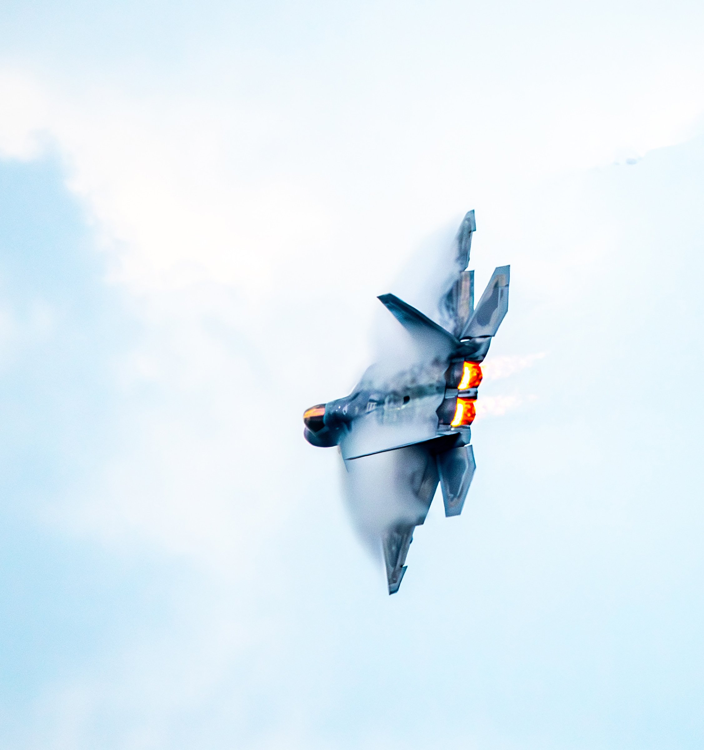 A fighter jet crashing into the ground, emitting smoke and fire from the rear, with a cloudy sky background.