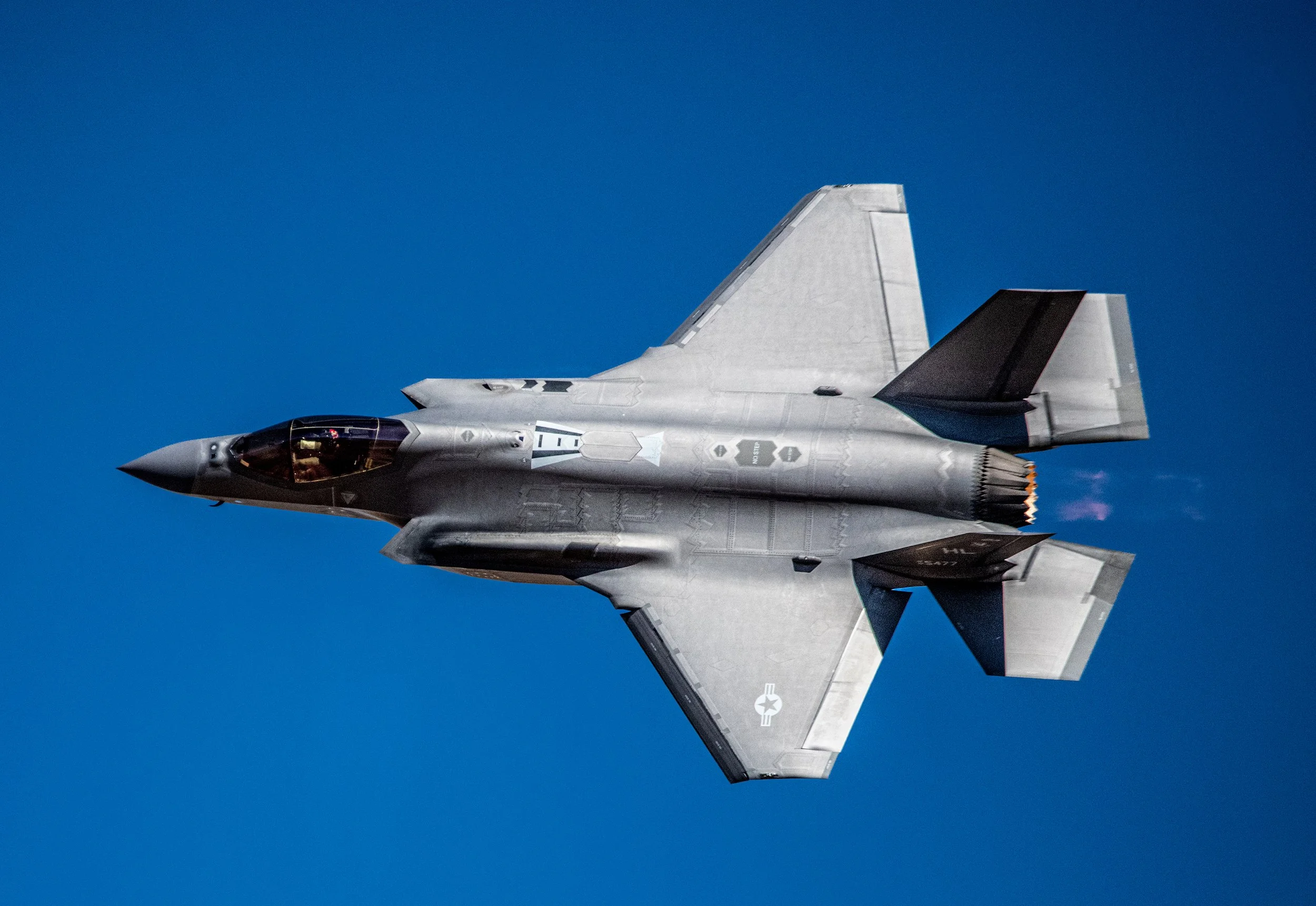 F-22 fighter jet flying against a clear blue sky.