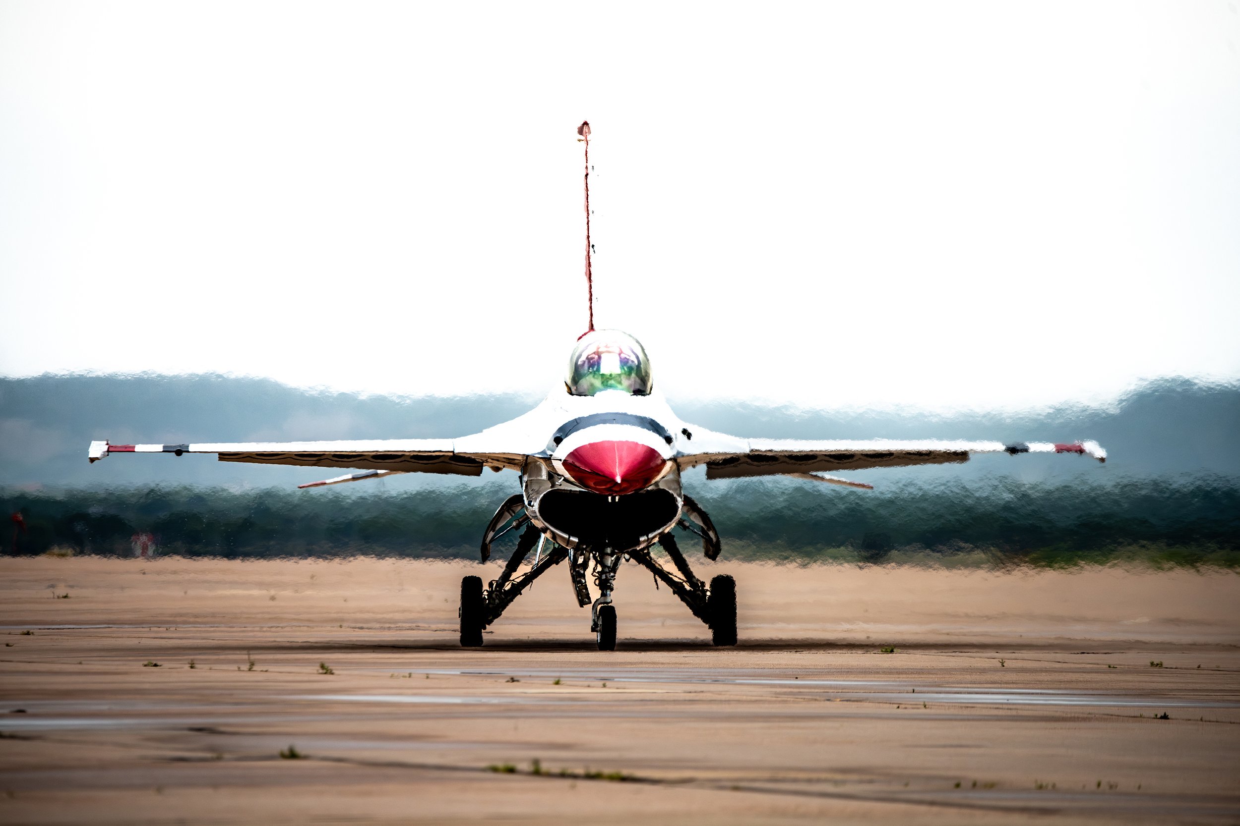 Fighter jet aircraft taxiing on the runway, facing forward, with the landing gear visible.