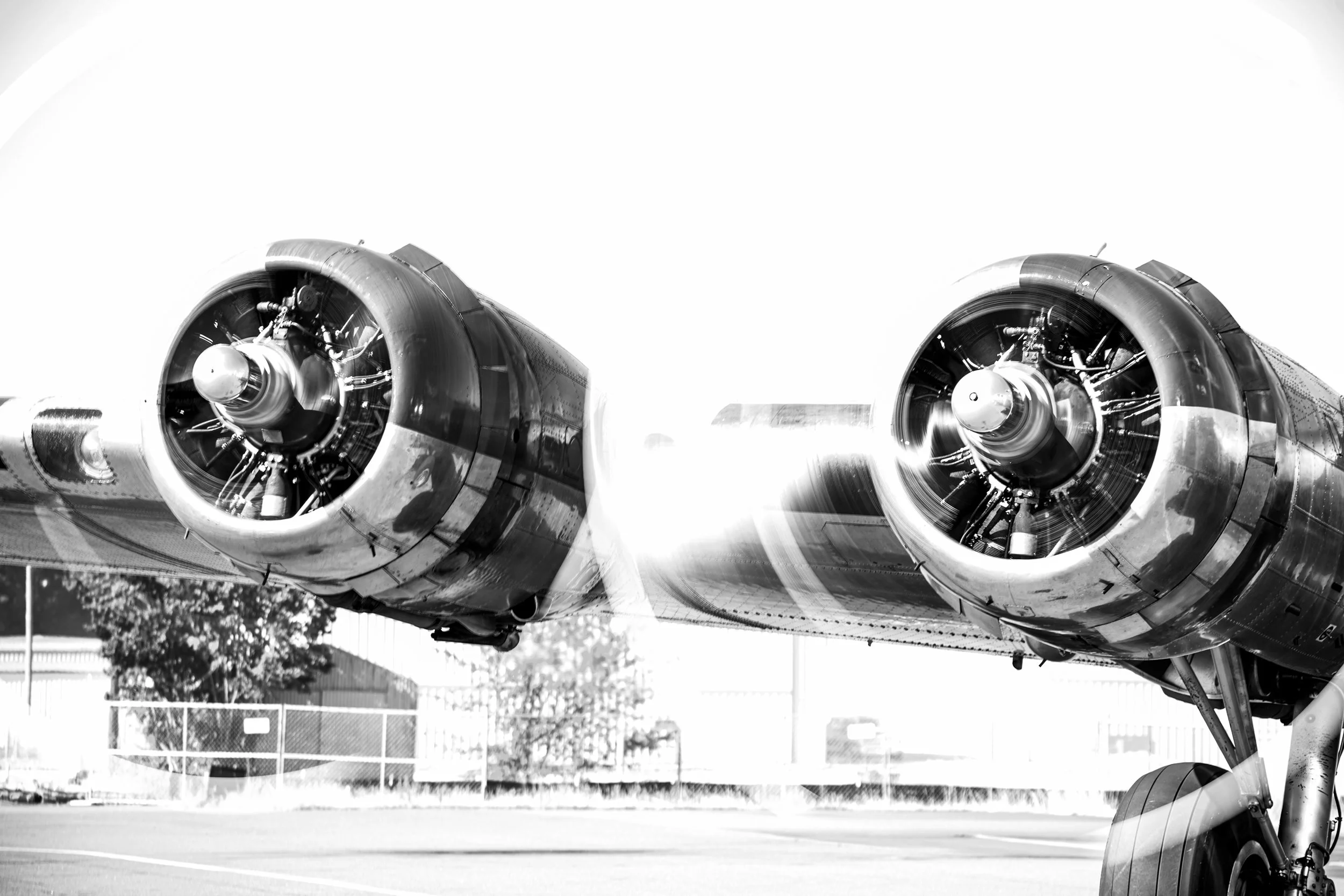Close-up of a vintage propeller airplane's engines in black and white.