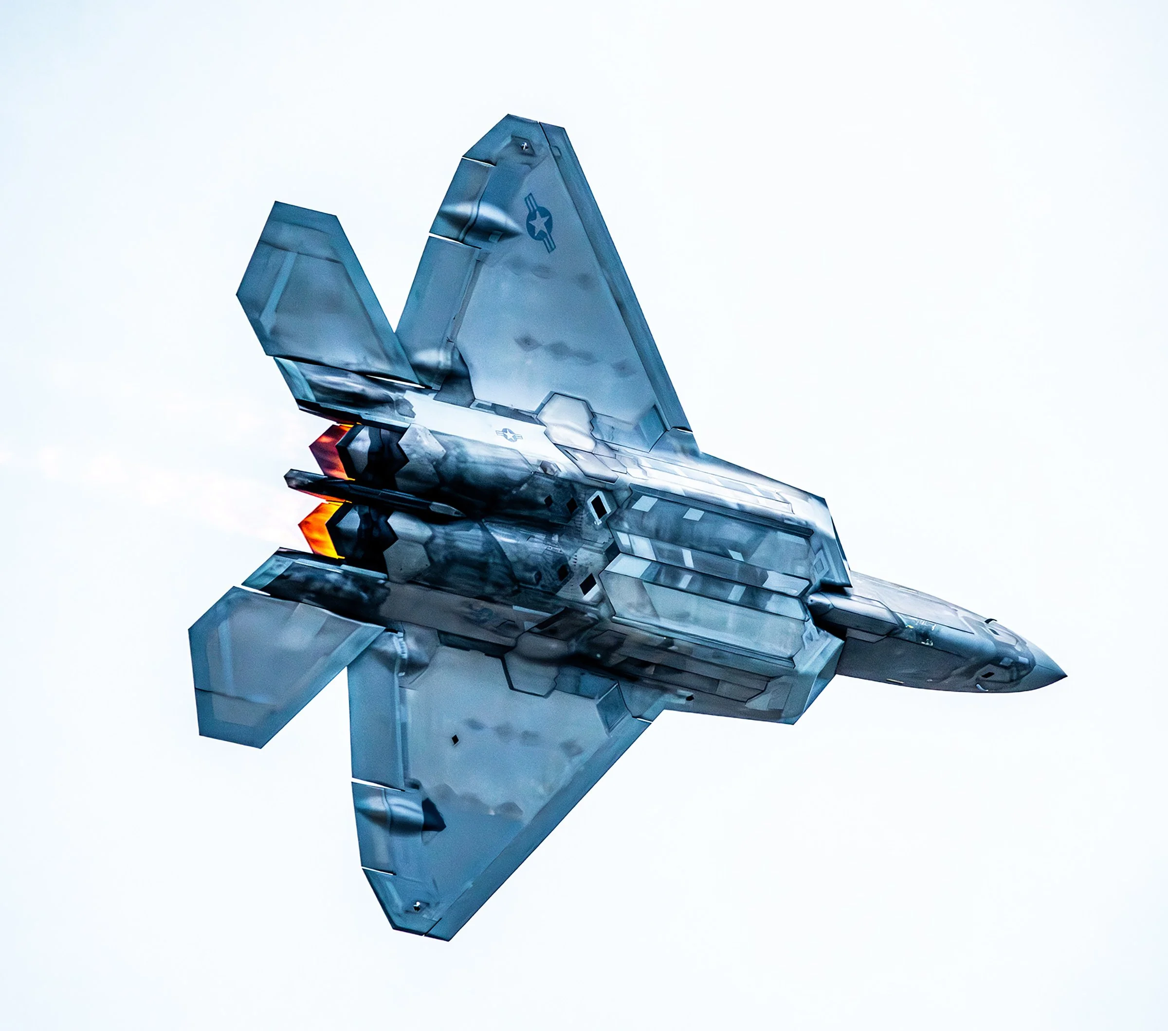 A fighter jet flying in the sky, shown from below, with a sleek gray body and angular wings.