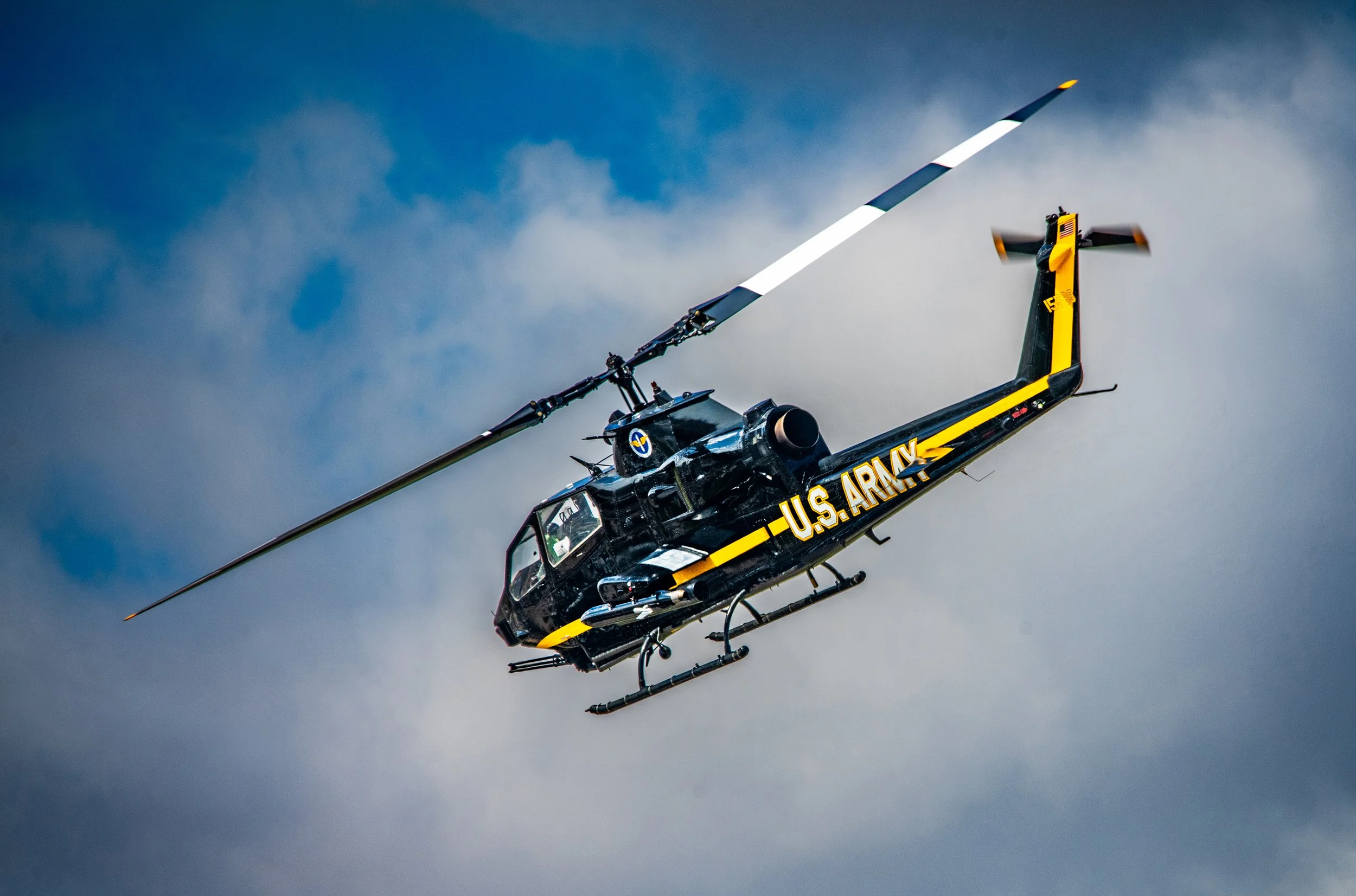 U.S. Army helicopter flying in cloudy sky.