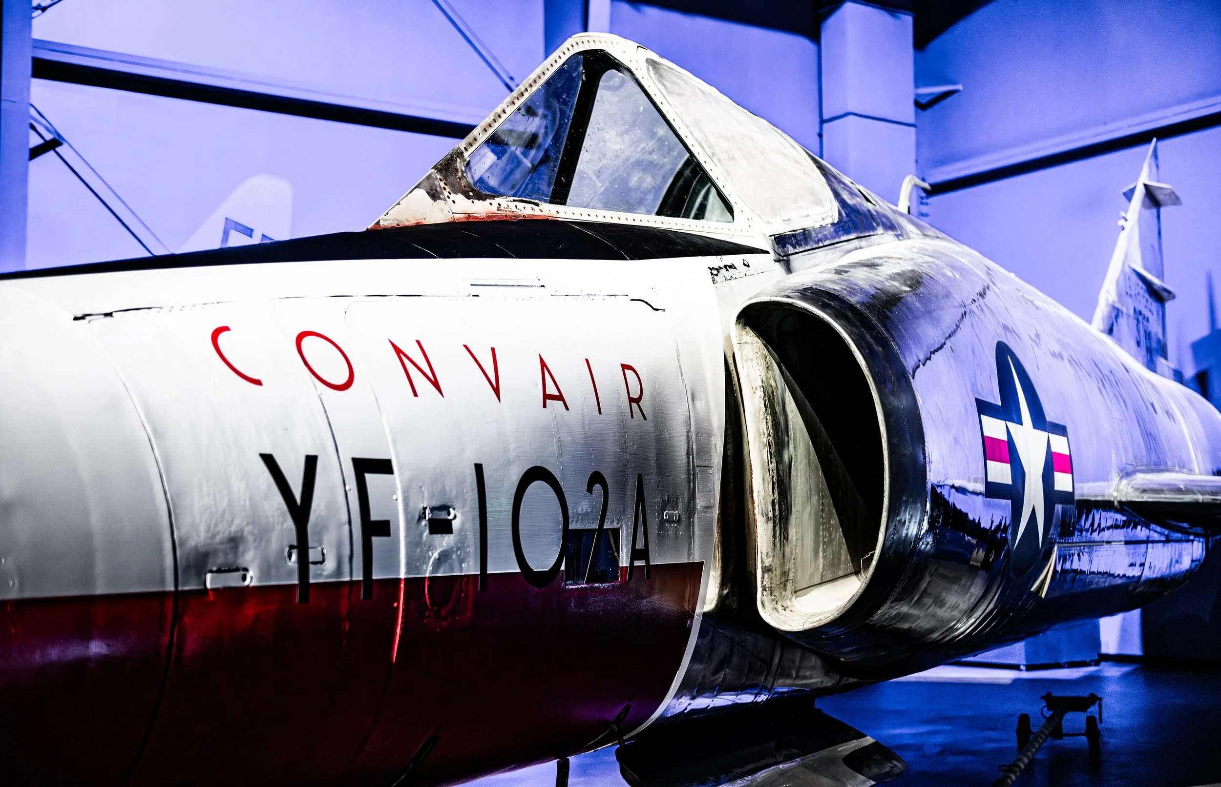 Close-up of a vintage fighter jet aircraft with a silver body, displaying the words "CONVAIR" and the designation "YF-10A" on the fuselage, and the U.S. Air Force roundel on the tail.