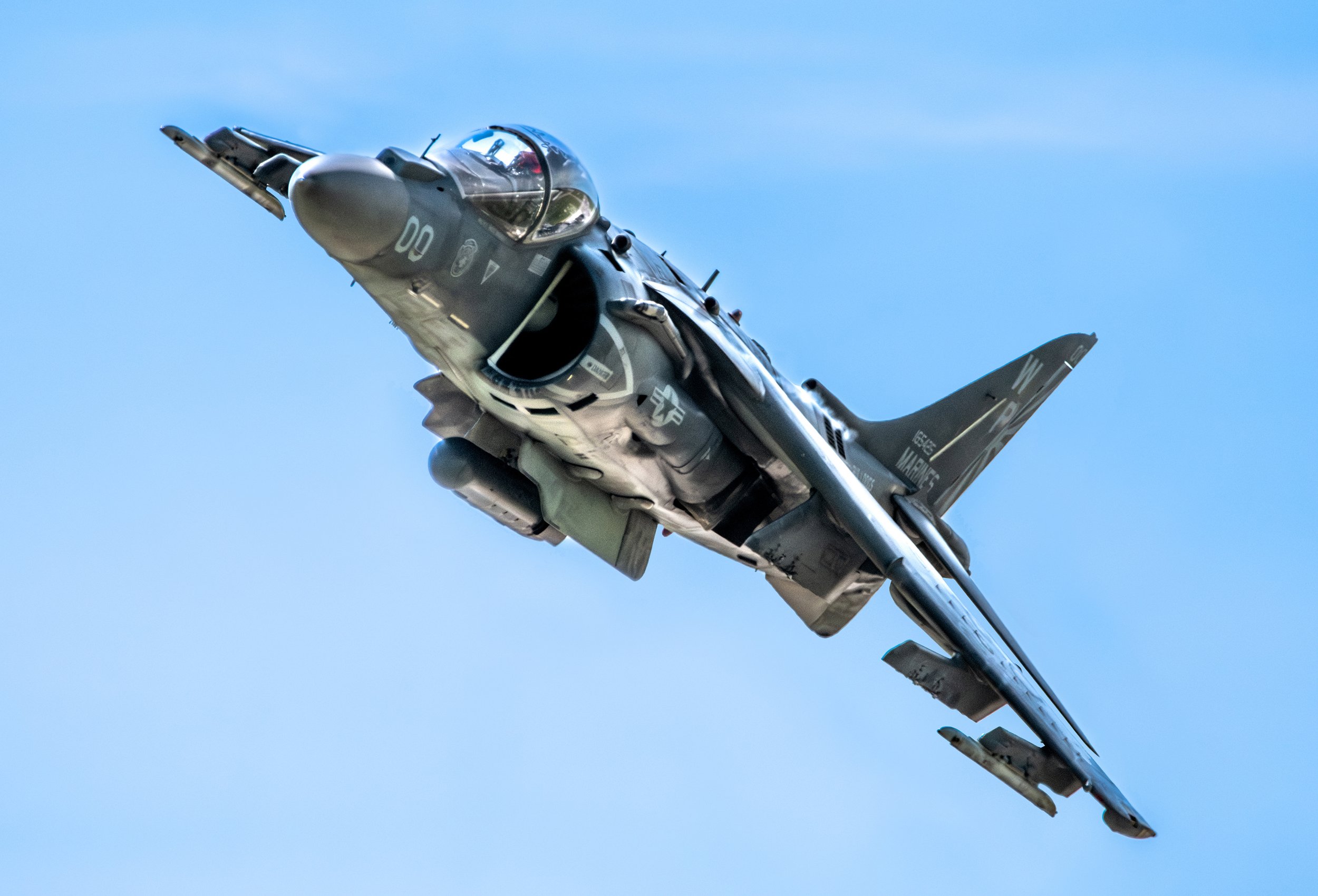 A military fighter jet flying in clear blue sky.