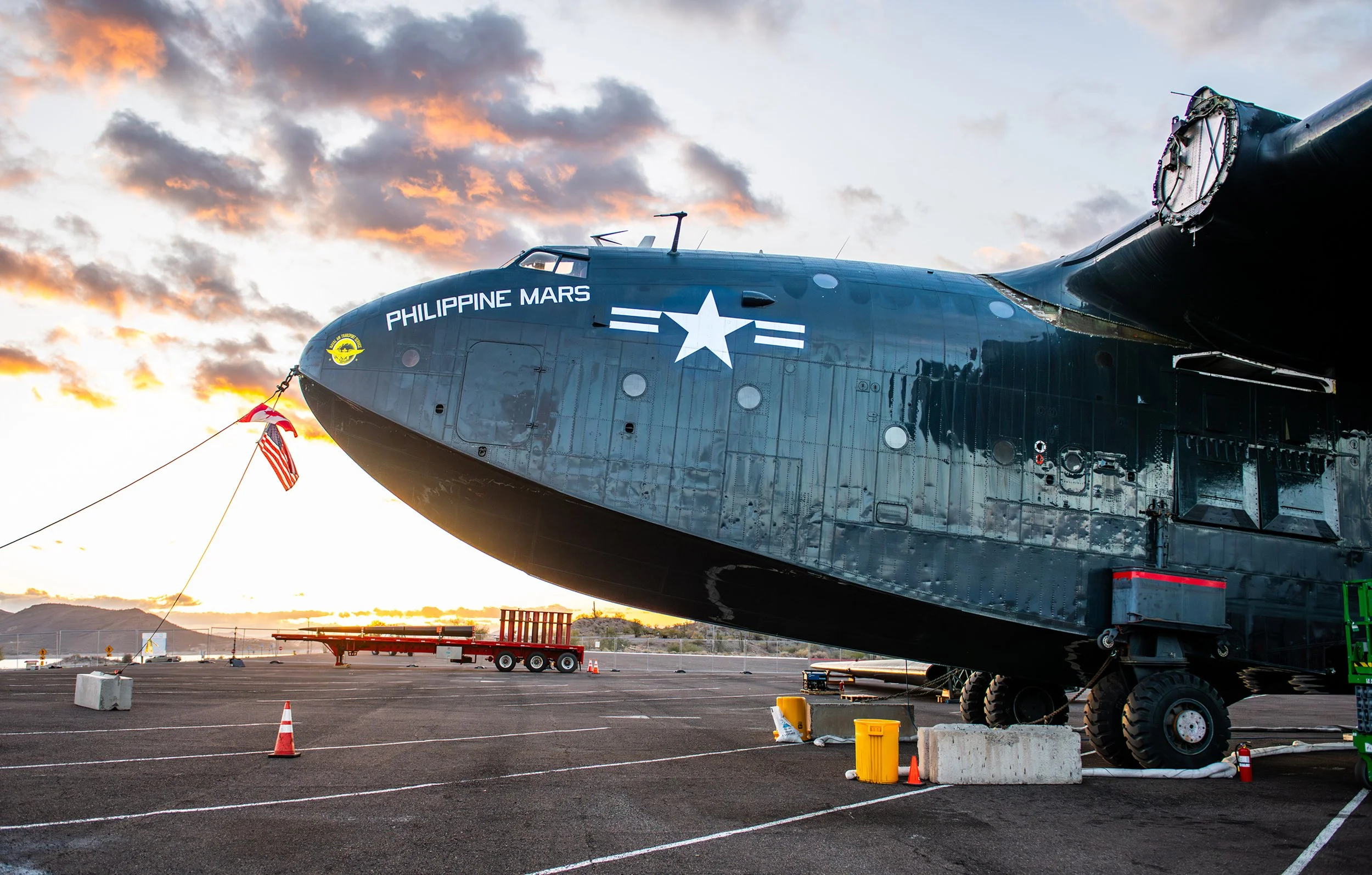 A large black submarine with the name 'Philippine Mars' painted on the side, displayed on a paved surface during sunset with clouds and a mountainous landscape in the background.