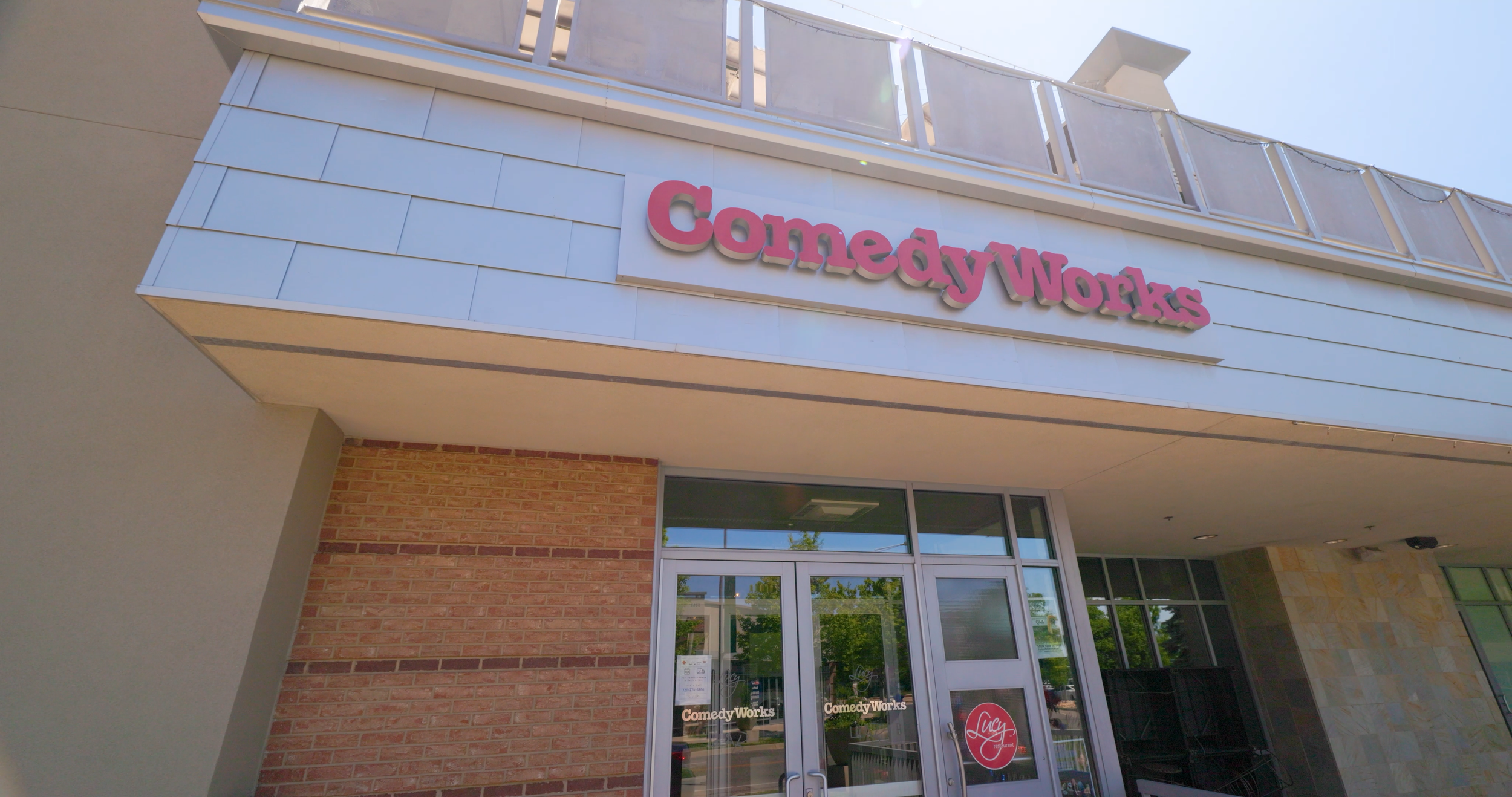 Exterior of a building with a sign that reads 'Comedy Works' in pink letters above the entrance.