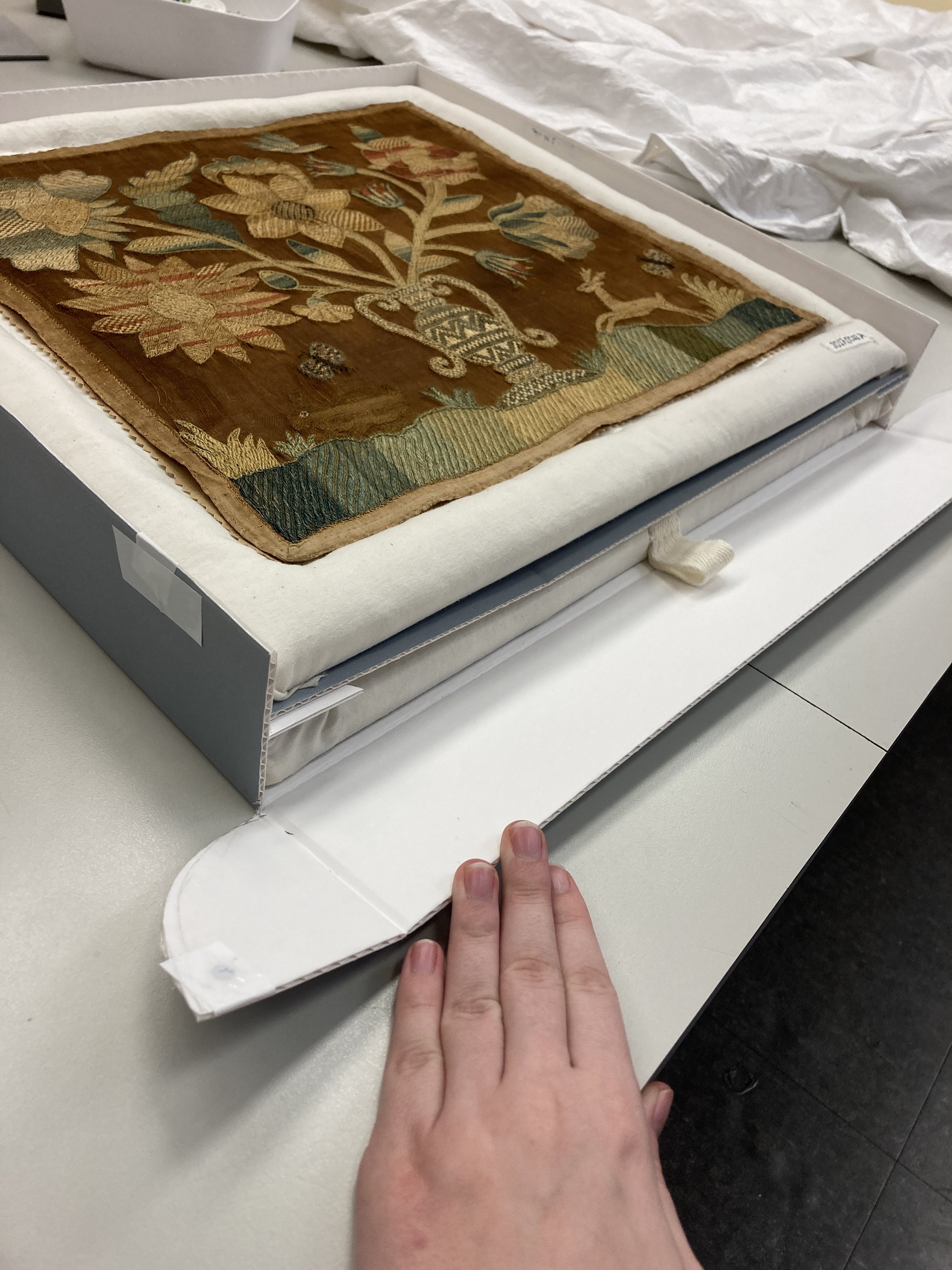 It has two levels. One for the needlework and the other for board.