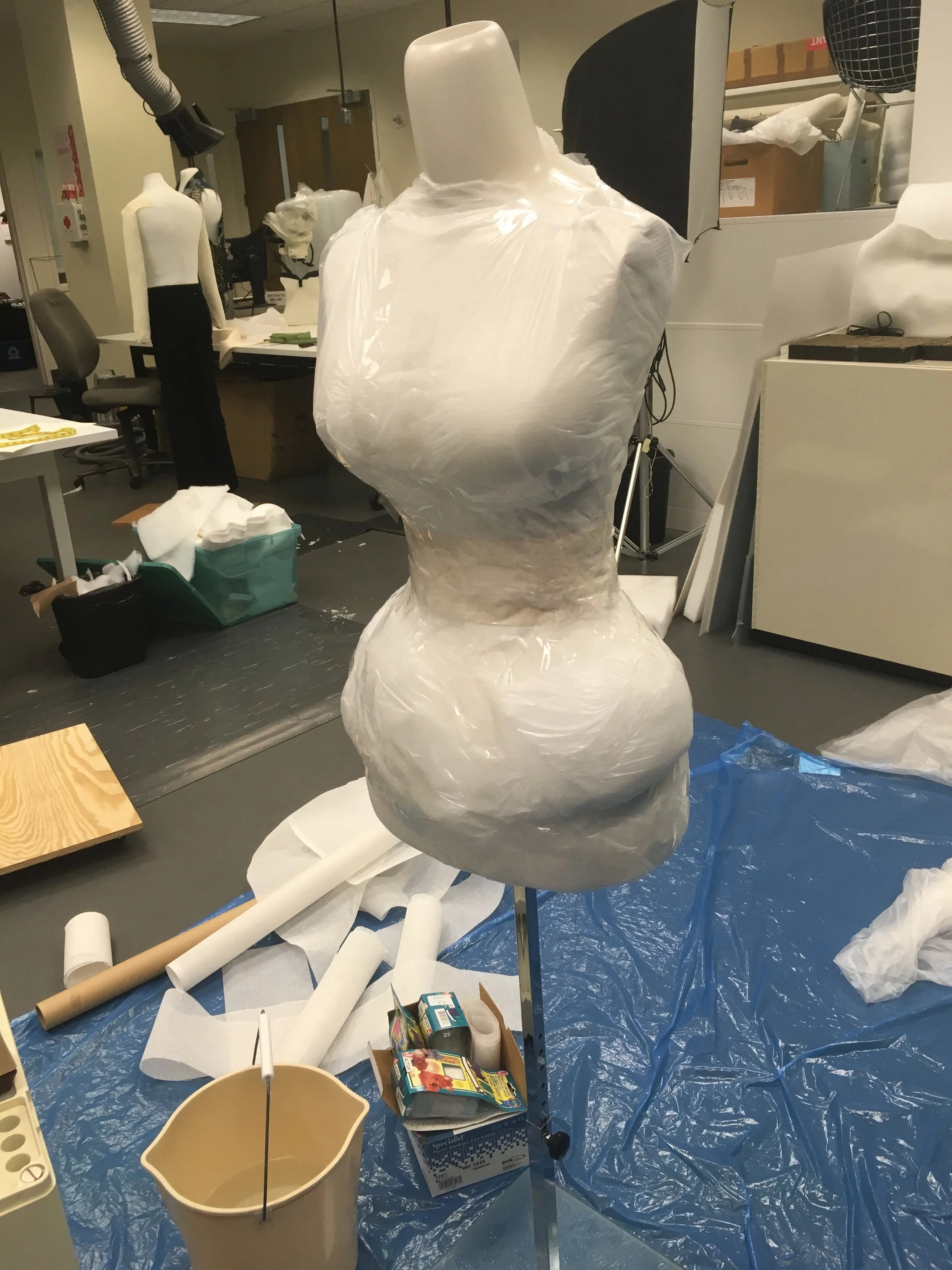 First and mannequin was modified so it fit the corset. It was then wrapped in plastic and taped down to protect the form.
