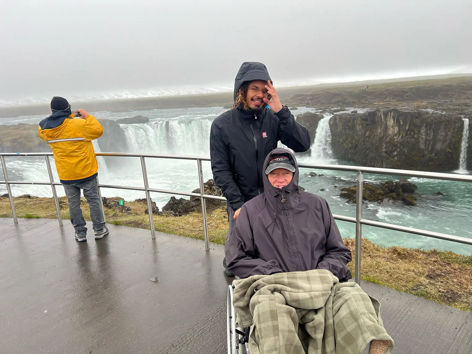 Wheelchair user and tour guide at the accessible viewpoint of Goðafoss waterfall in Iceland