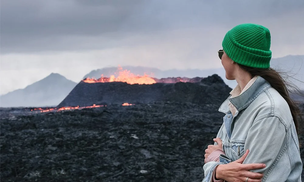 Women looking a volcano eruption in Reykjanes