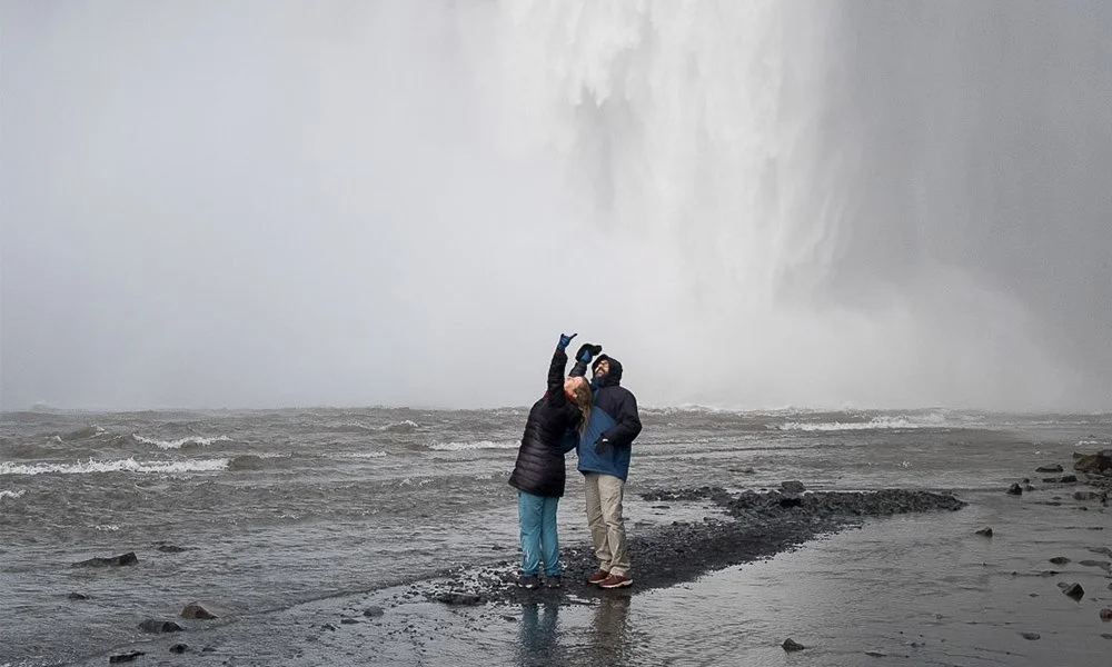 People in the Skogafos waterfall in the south coast of Reykjanes
