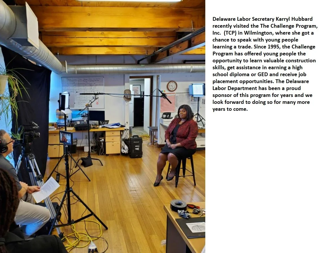 Delaware Labor Secretary Karryl Hubbard speaking in an interview setup with cameras and crew in a wood-paneled office.