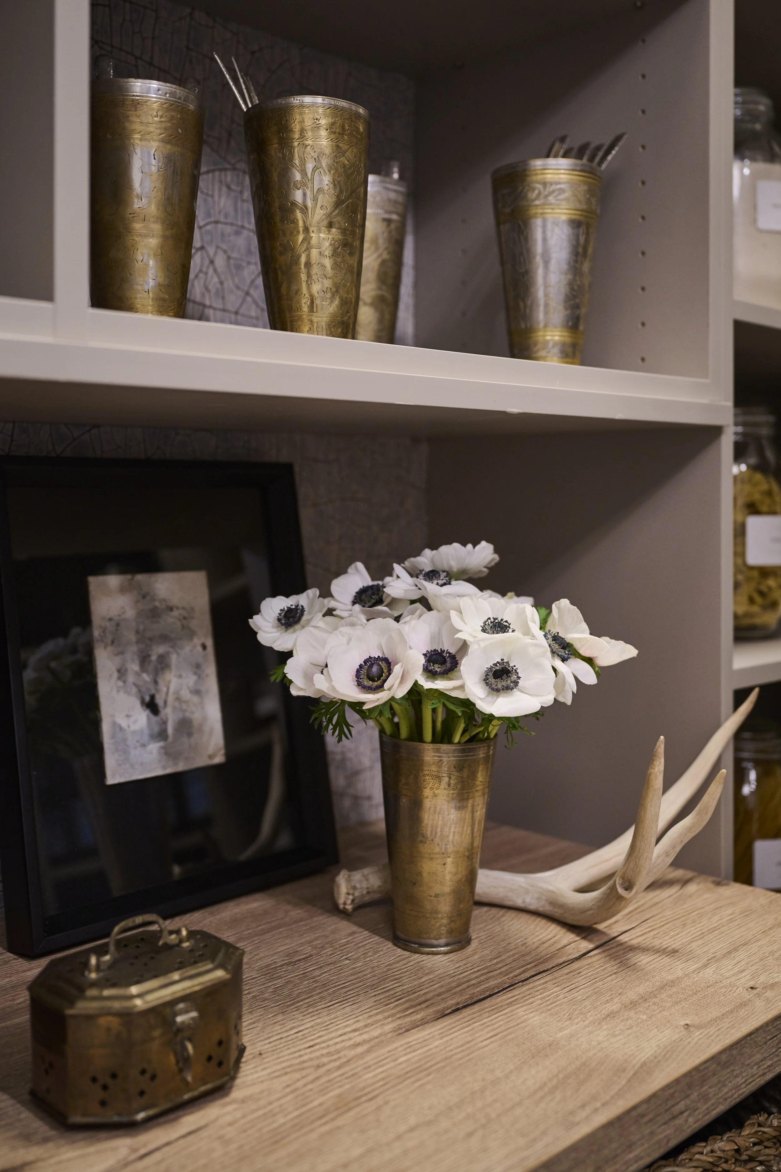 Serenbe Showhouse Pantry Vignette. Wallpaper from Arte Wallcoverings at Paul Plus with a Holly Hunt Tape Trim Border. Antique Indian Wedding Cups layered with a cricket box, artwork from B.D. Jeffries, fresh anemone flowers, and a found antler.