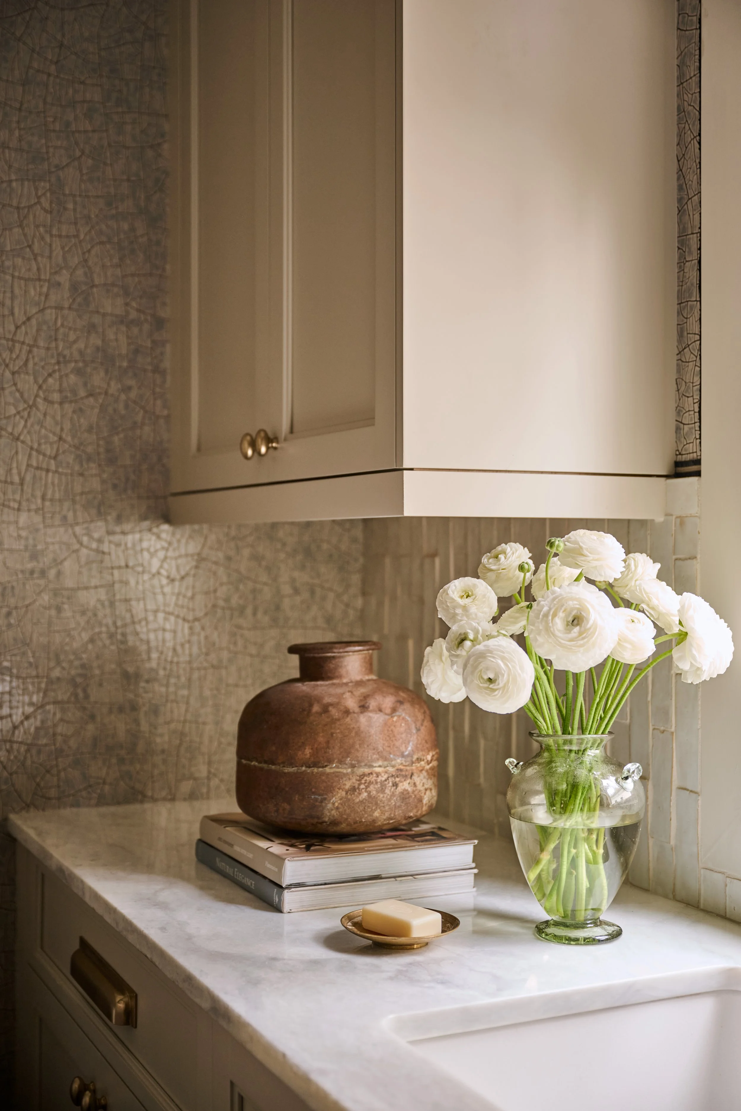 Serenbe Showhouse Laundry Counter top. Wallpaper from Arte Wallcoverings at Paul Plus with a Holly Hunt Tape Trim Border. Layered with collected accessories and fresh ranunculus flowers.