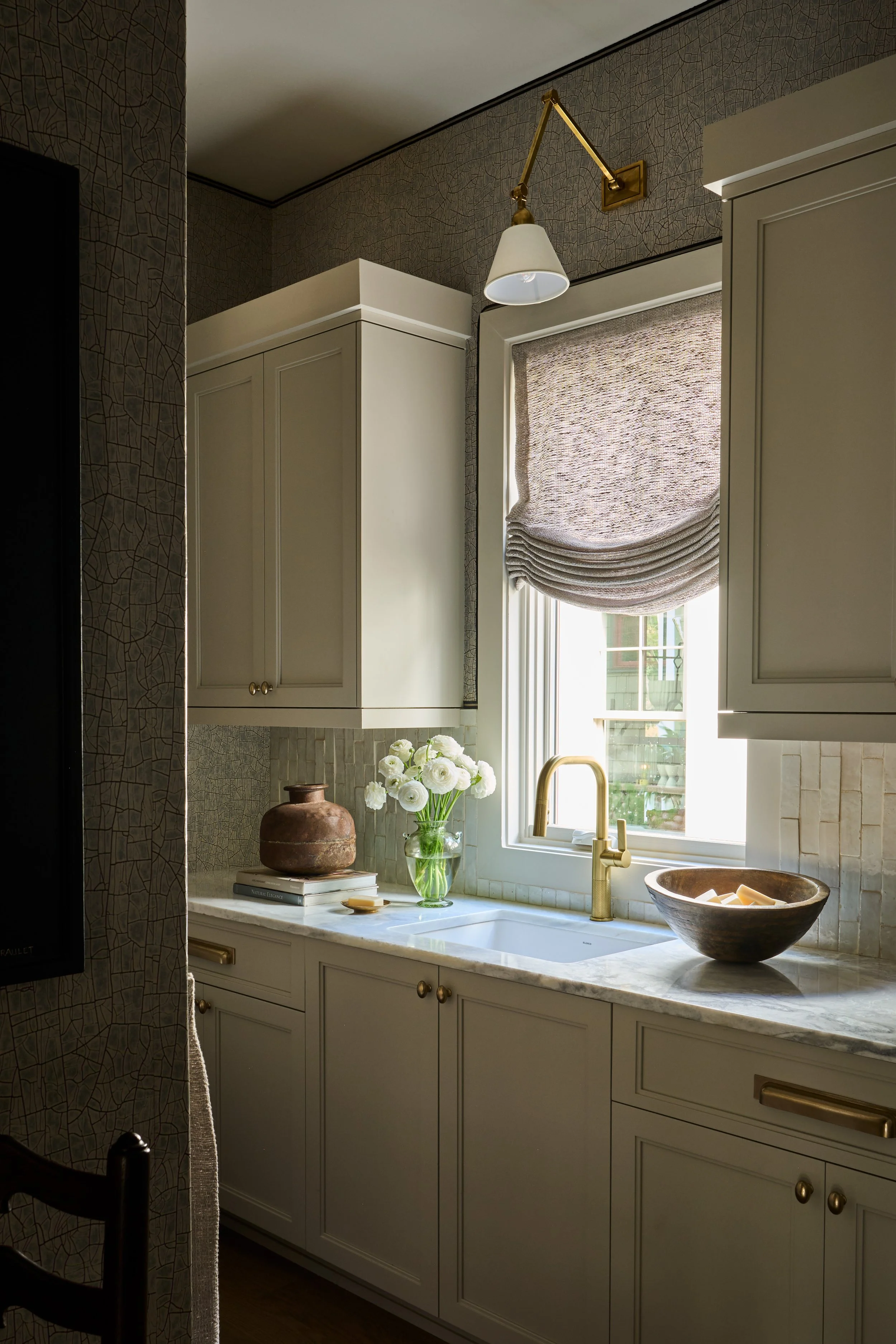 Serenbe Showhouse working laundry sink. Wallpaper from Arte Wallcoverings at Paul Plus with a Holly Hunt Tape Trim Border. Custom sheer linen roman shade by The Drapery Room. 