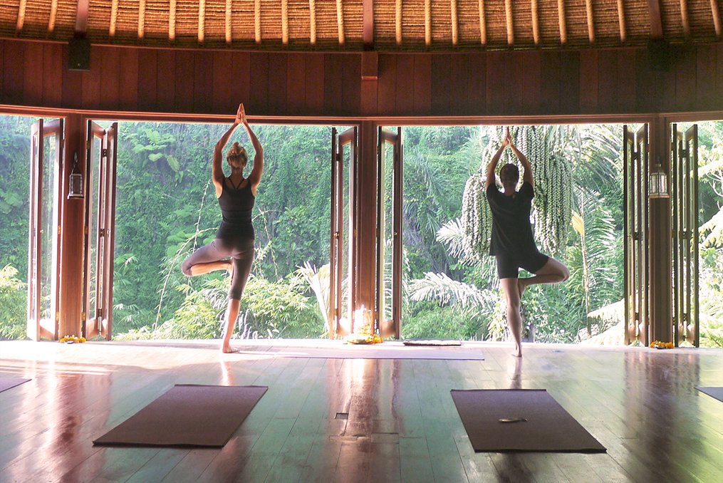Brigid Moloney practicing yoga in a studio in Ubud, Bali on retreat, surrounded by lush greenery.