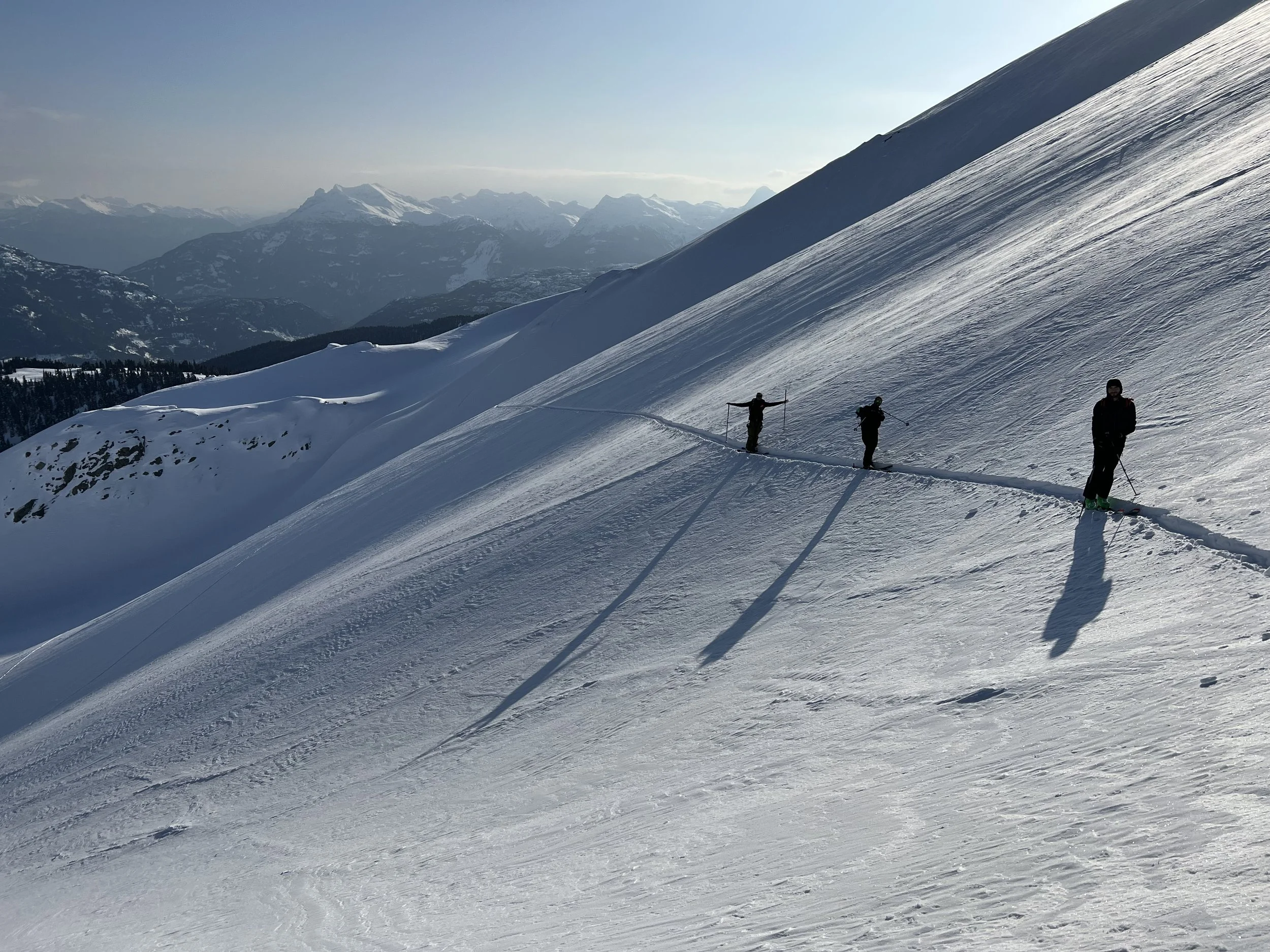 Happy clients nearing the summit of Rainbow mountain after a quick helicopter bump and a great ski run.